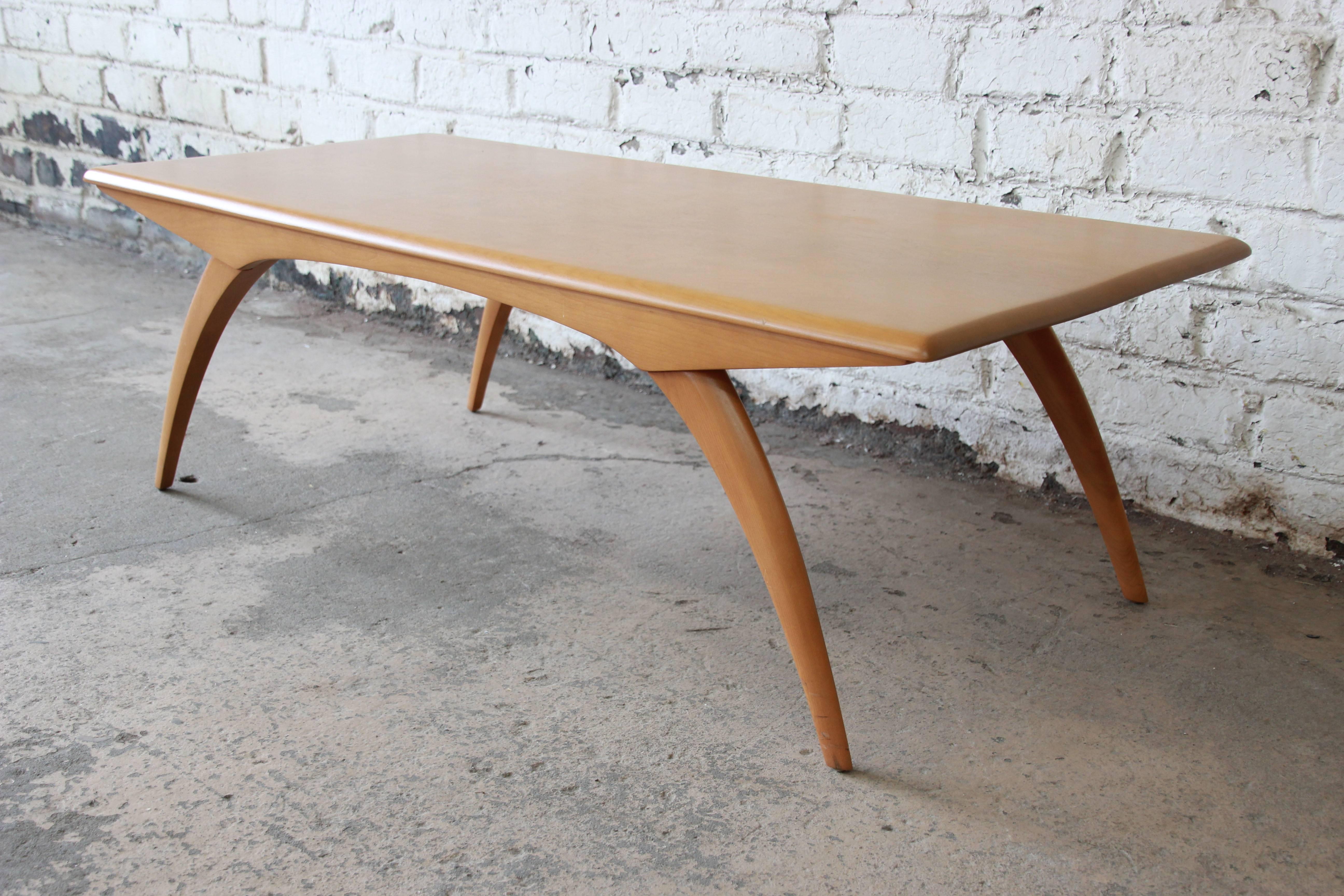 Offering an excellent original condition Heywood-Wakefield coffee table. The table has iconic wishbone legs that give the table a sleek Mid-Century Modern look. It has nice large surface that is in great original condition. Very minor wear from age