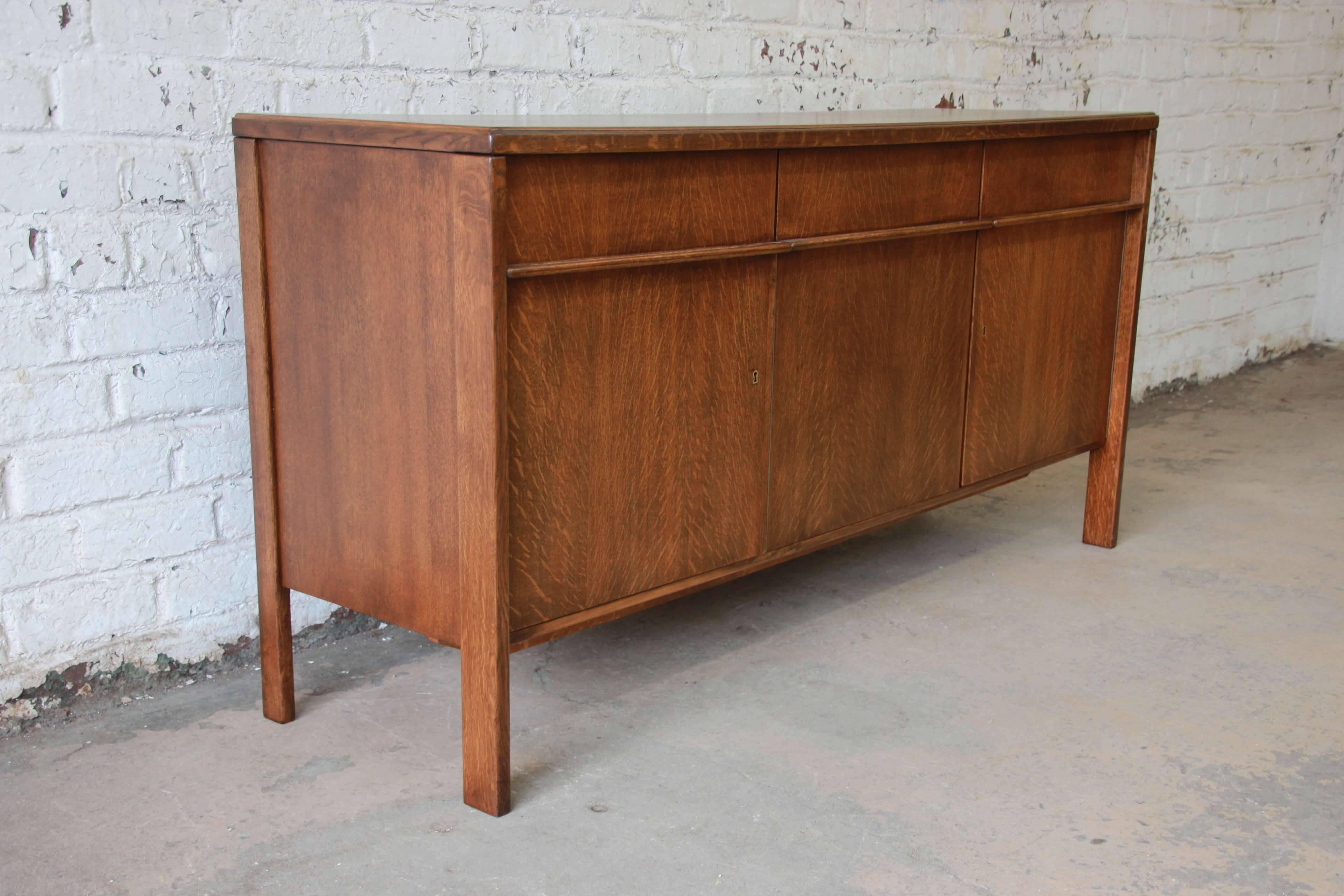 Offering a rare beautifully restored Scandinavian Modern quarter sawn oak sideboard credenza by Cees Braakman for Pastoe. This piece has three uniquely designed drawers at the top and directly below are three cabinet doors. The left cabinet door