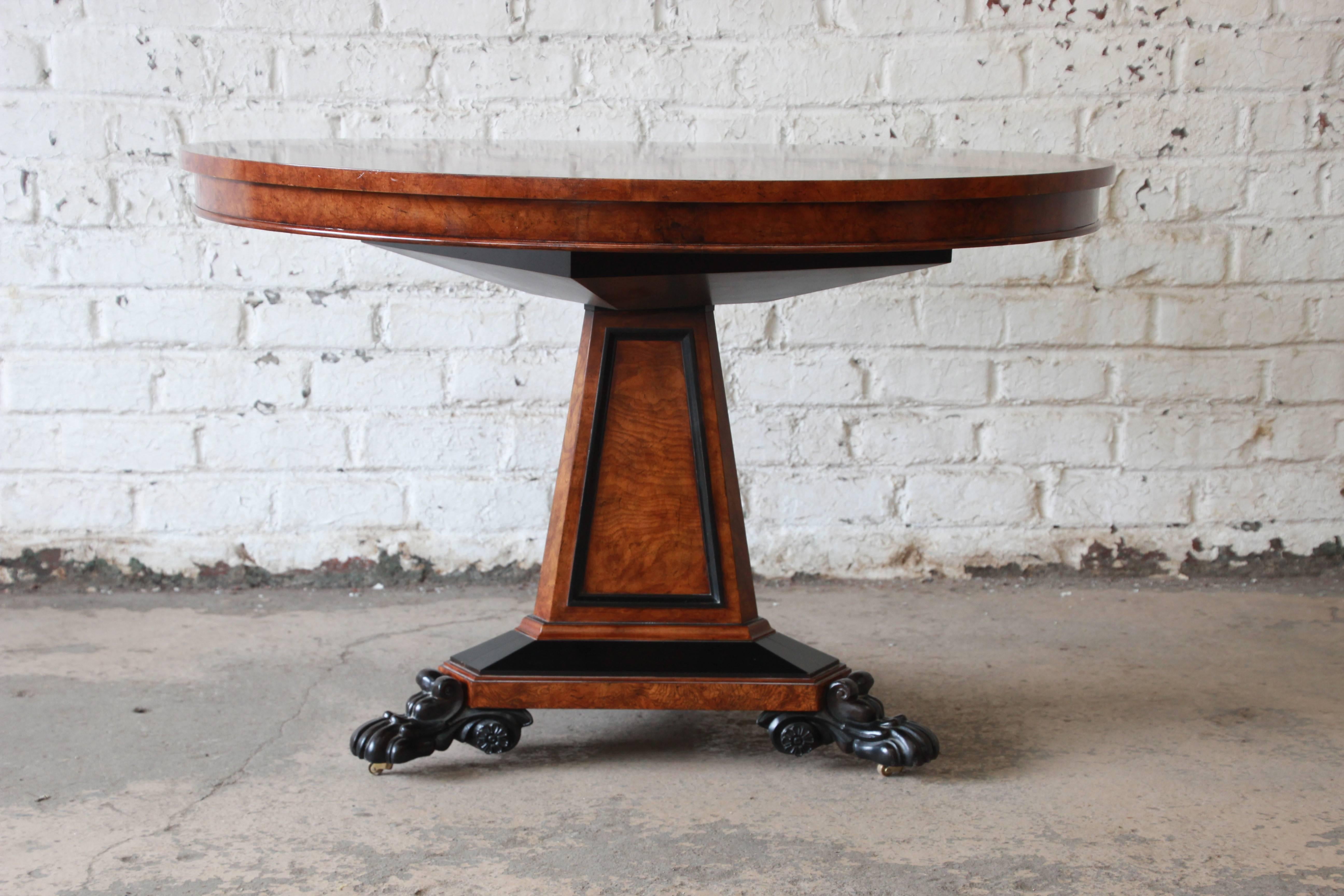 The Regency centre table, a rare piece, was designed in circular burl ash by George Bullock for Baker Furniture's Stately Homes collection. Adorning the inlaid top is a broad border of ebonized floral vines within ebonized bands. The frieze follows