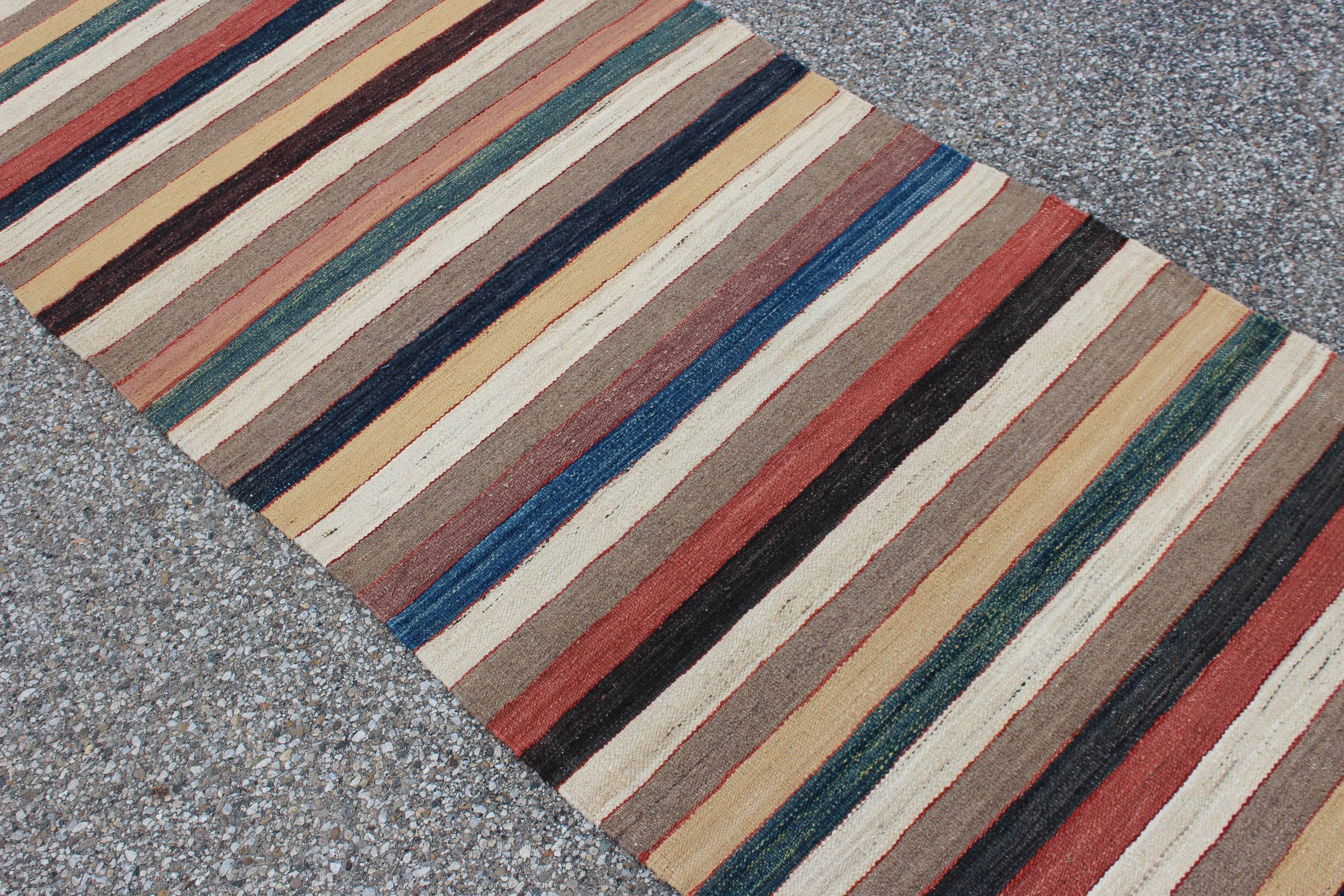 A gorgeous vintage handwoven Maimana Afghan Kilim runner rug. The rug is hand made from 100% wool with vegetable dyes. It has a beautiful multicolored stripe design, with natural colors. The rug is in excellent condition.