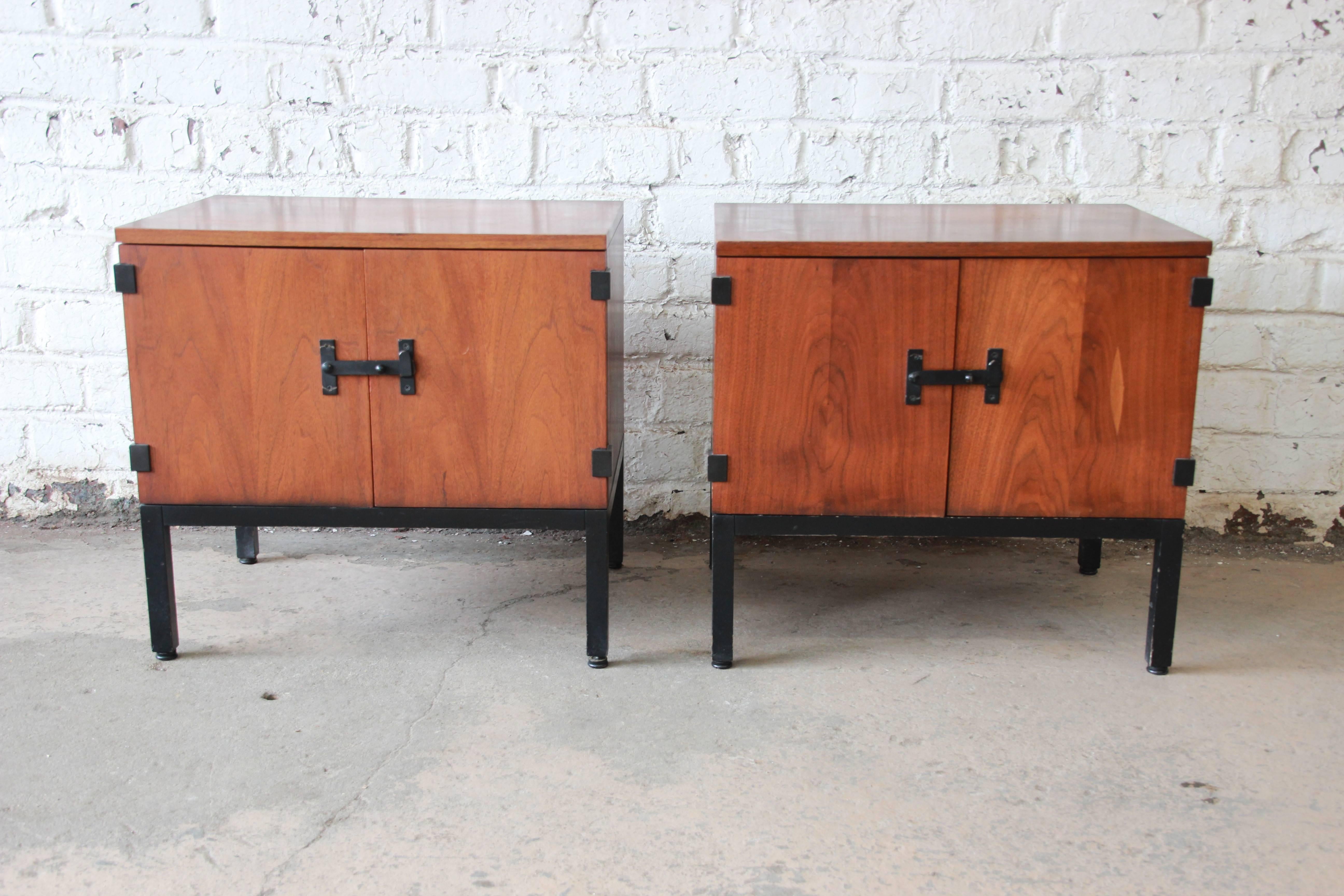 A stunning pair of Mid-Century Modern walnut nightstands or side tables designed by Kipp Stewart for Directional, circa 1960s. The tables feature gorgeous book-matched walnut wood grain, with sculpted ebonized pulls and ebonized bases. They offer