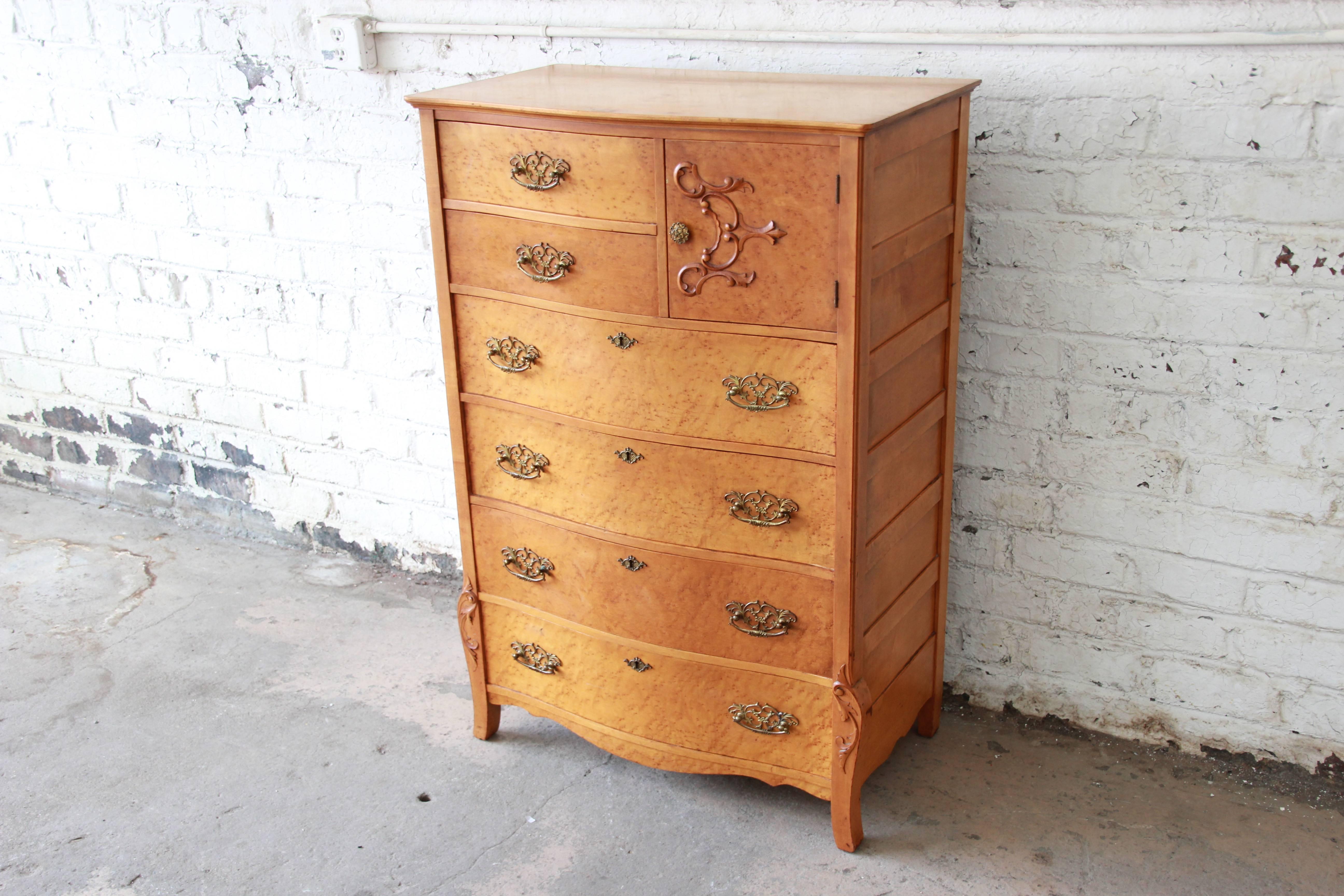 A gorgeous antique bird's-eye maple highboy dresser by Widdicomb Furniture Co. of grand rapids. The dresser features beautiful bird's-eye maple wood grain and original brass hardware. It offers ample room for storage, with six dovetailed drawers and