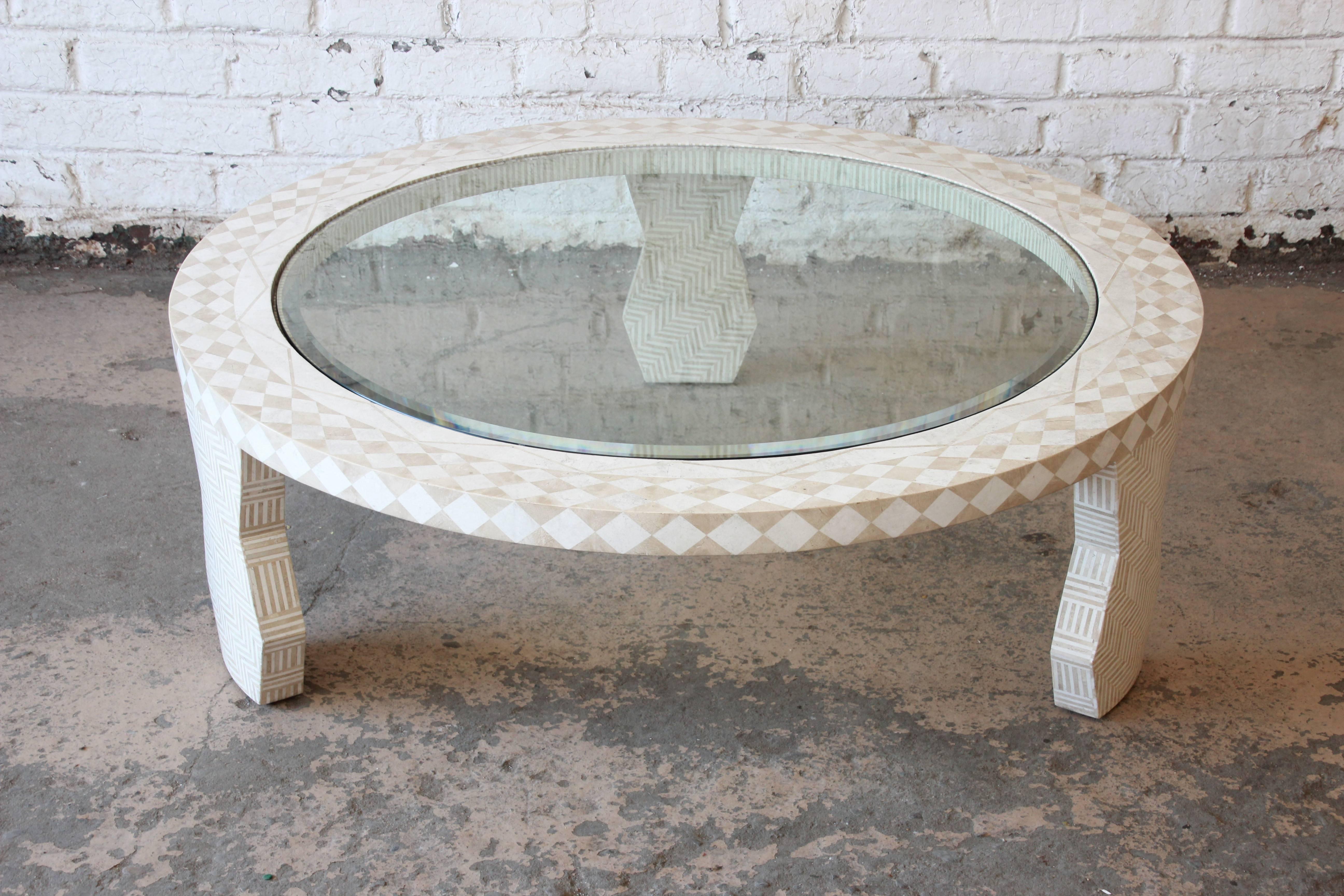 A stunning tessellated stone and glass large round Mediterranean style coffee or cocktail table from the Tavola Collection by Oggetti. This high quality table features hand inlaid tessellated white and beige stone detailing throughout, including the