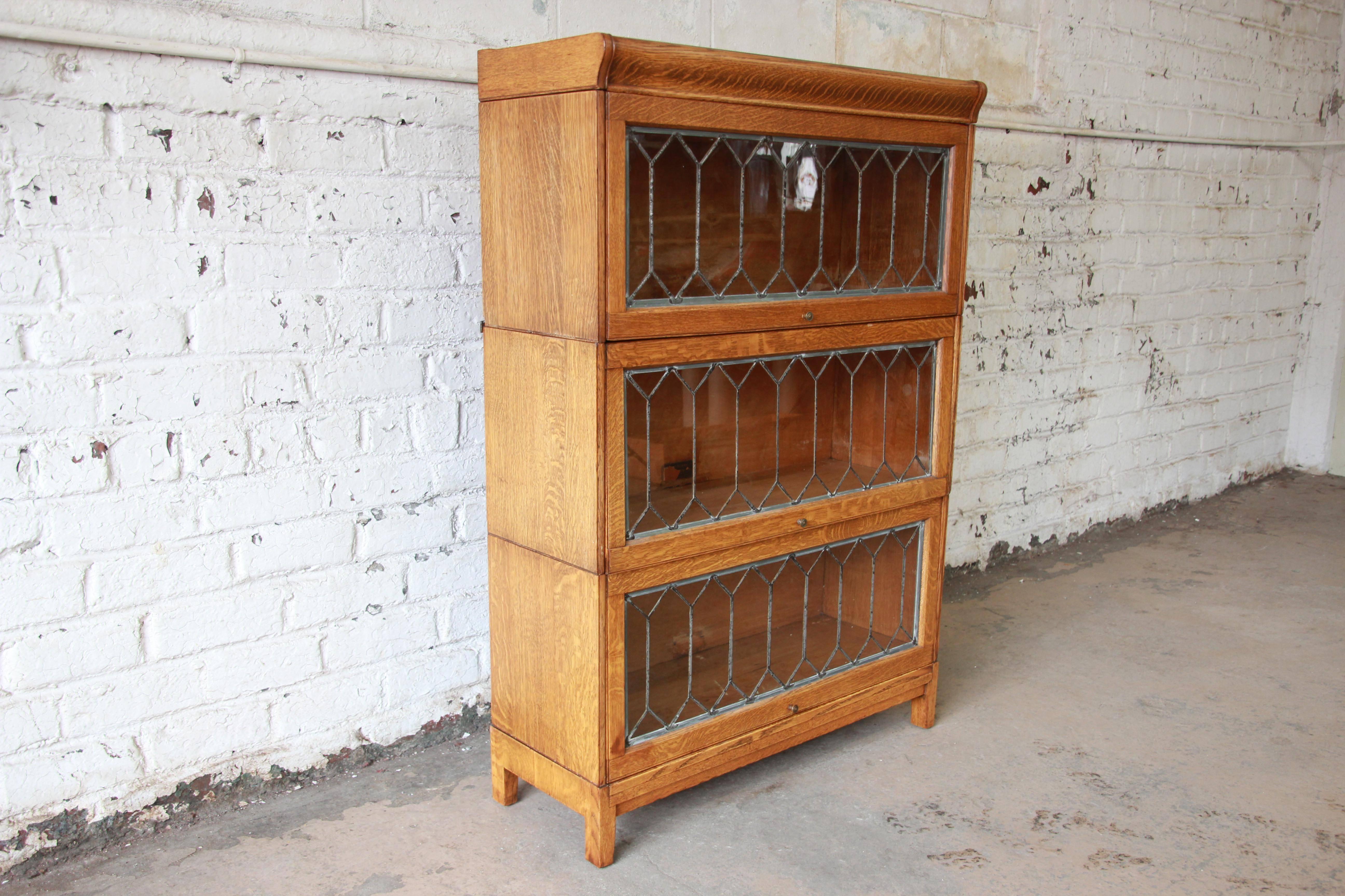 Offering a stunning tiger oak three-stack barrister bookcase with leaded glass by Hale's of Herkimer. This piece has a beautiful wood grain enhanced by three leaded glass front doors. This barrister originates in the early 1900s and is in great