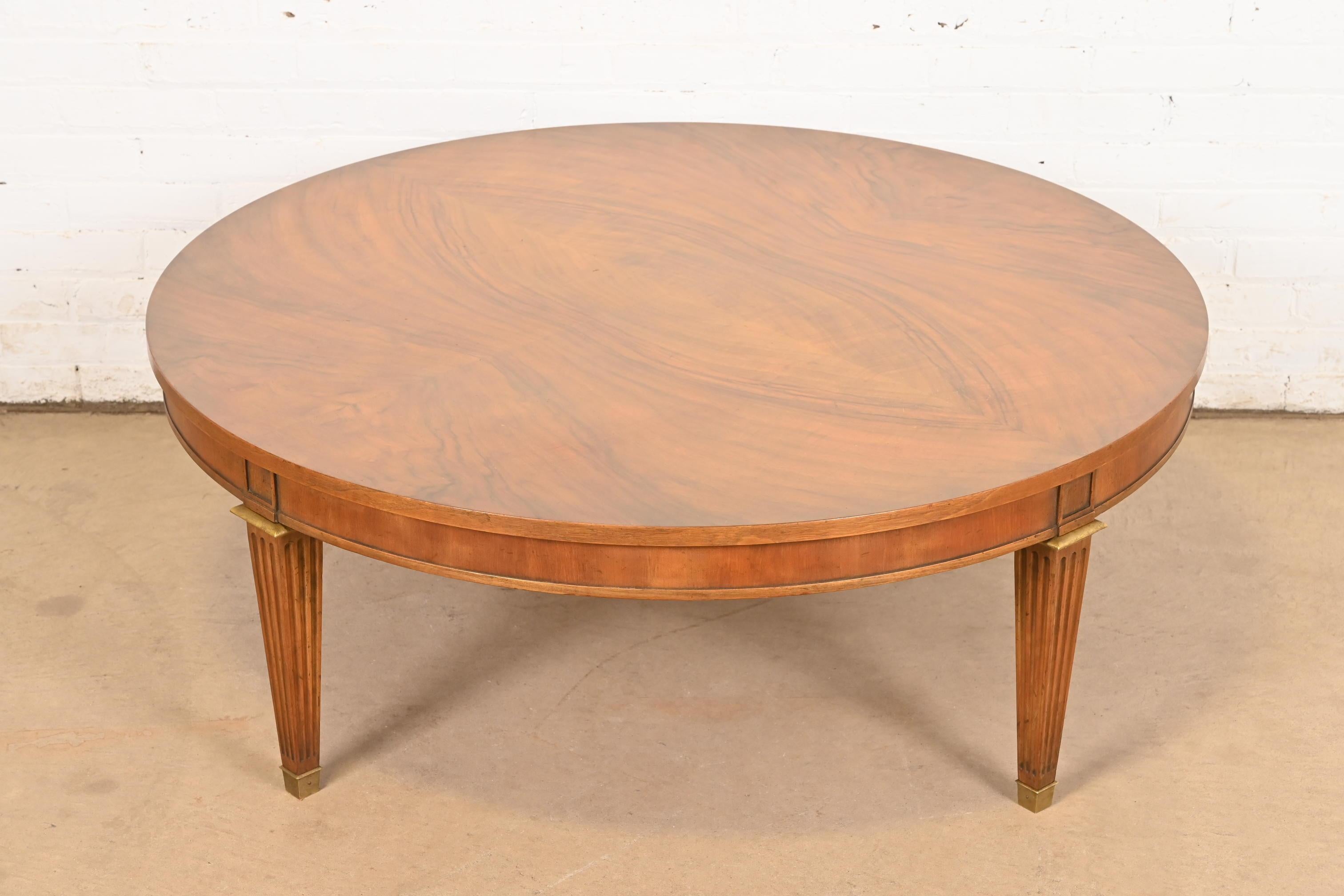 Ein prächtiger Couchtisch oder Cocktailtisch im französischen Regency-Louis-XVI-Stil aus der Mitte des Jahrhunderts

Von Baker Furniture

USA, ca. 1960er Jahre

Wunderschöne Platte aus genopptem Nussbaum mit geschnitzten Nussbaumbeinen und