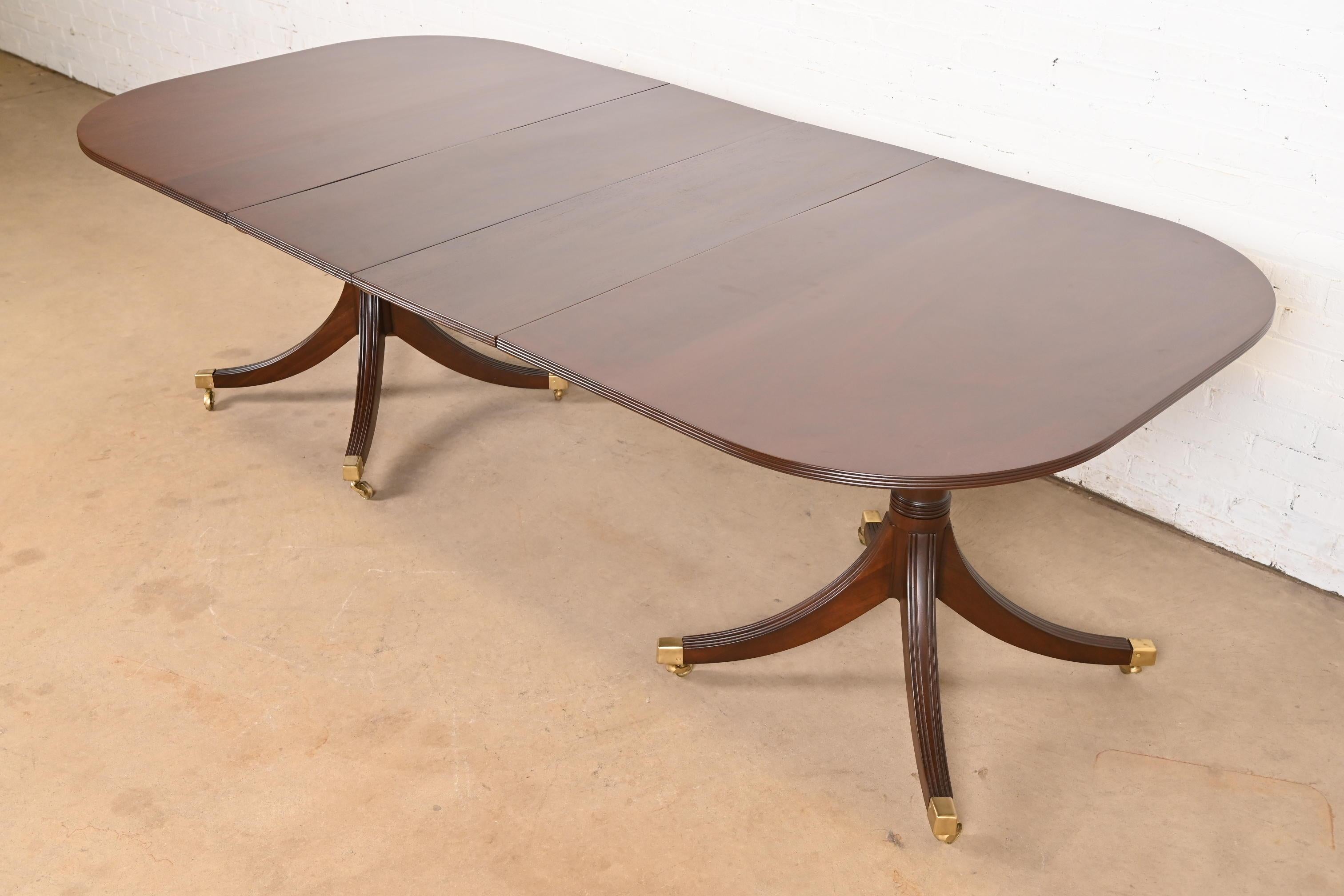 Exceptionnelle table à manger à rallonge à double piédestal de style Géorgien ou Régence.

À la manière des meubles Baker

États-Unis, vers les années 1940

Magnifique acajou, avec des piédestaux en acajou massif sculpté, et des pieds coiffés de