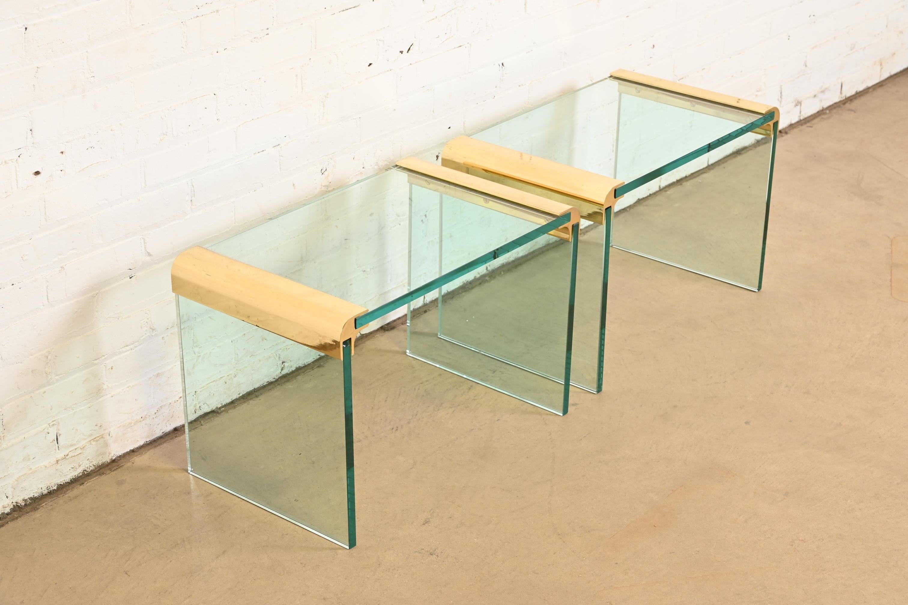 A gorgeous pair of mid-century modern Hollywood Regency brass and glass side tables or nightstands

By Leon Rosen for Pace Collection

USA, Circa 1970s

Measures: 24.75