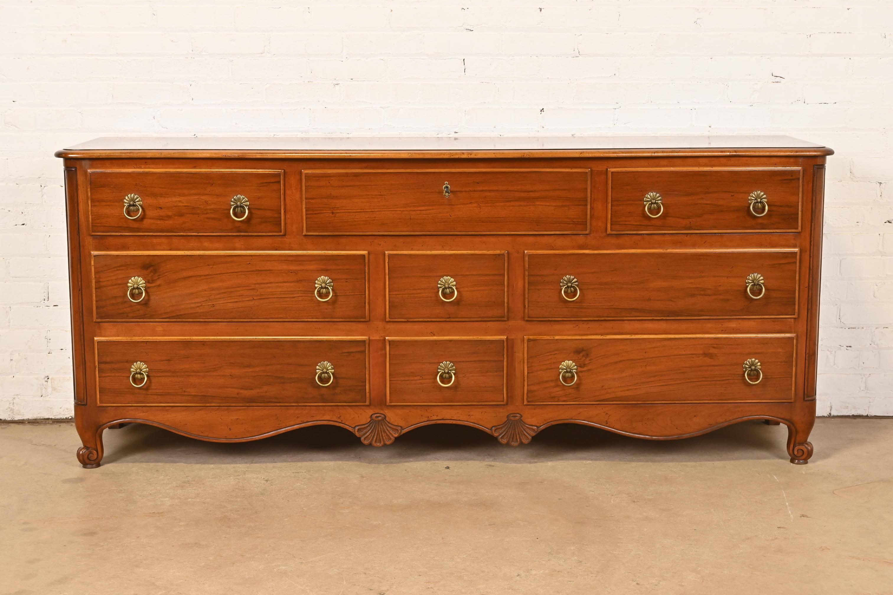 Un'eccezionale cassettiera o credenza a nove cassetti in stile Luigi XV francese.

Da Baker Furniture

USA, circa anni '1960

In legno di noce intagliato, con fianchi in noce burattato e ferramenta originale in ottone. Il cassetto centrale superiore