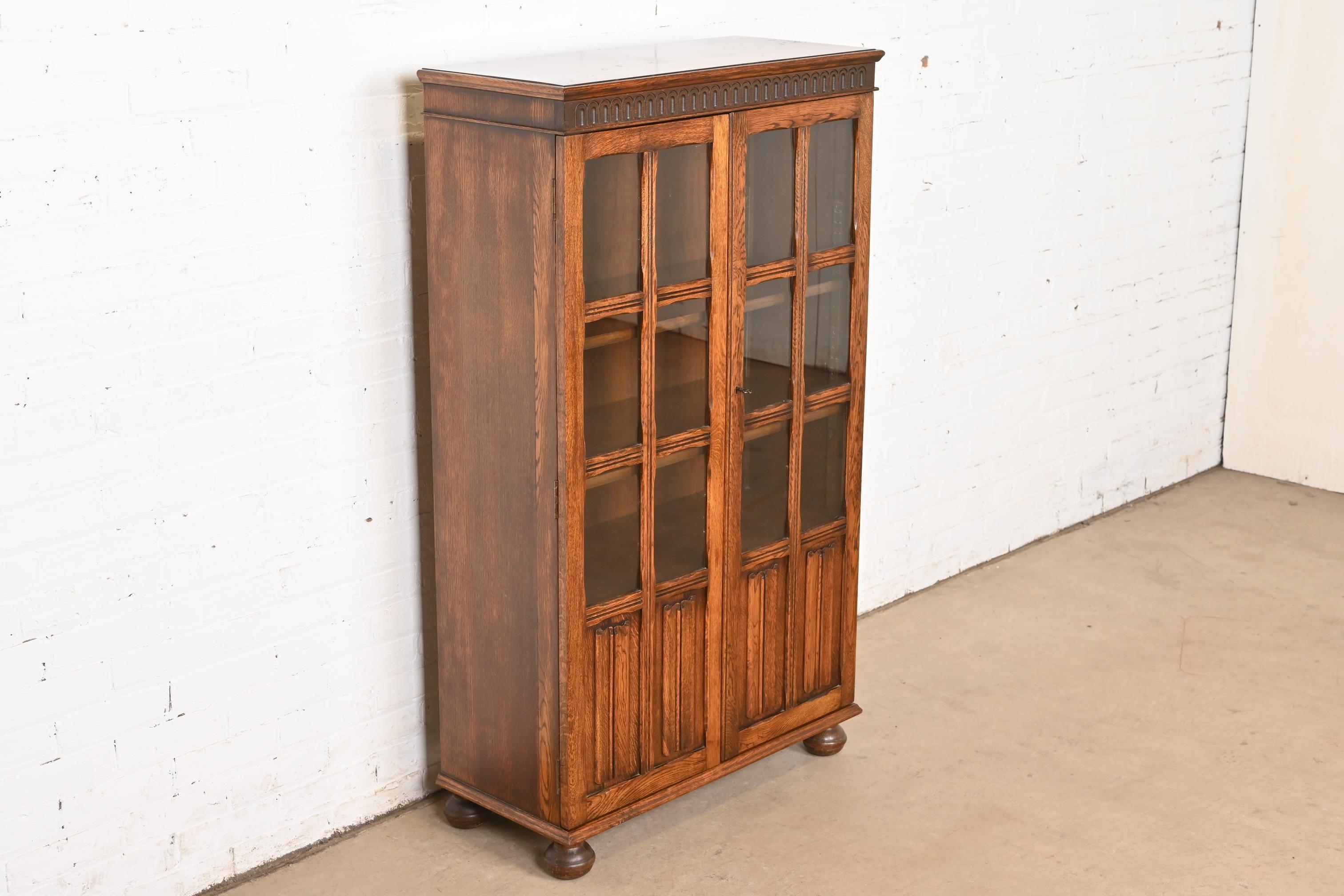 Début du 20ème siècle Ancienne armoire bibliothèque à façade vitrée en Oak Oak Tudor sculpté, vers 1920 en vente