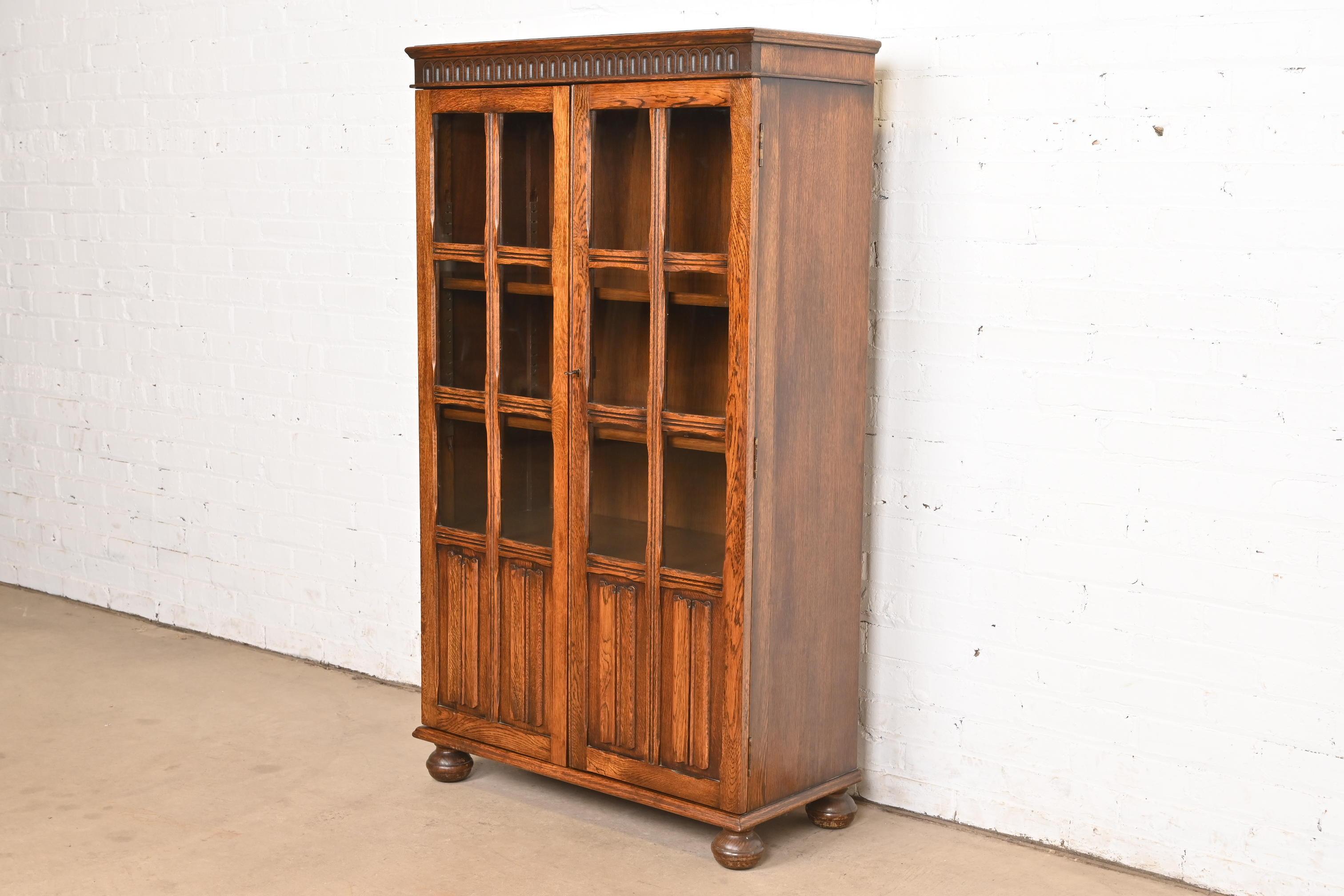 Ancienne armoire bibliothèque à façade vitrée en Oak Oak Tudor sculpté, vers 1920 Bon état - En vente à South Bend, IN