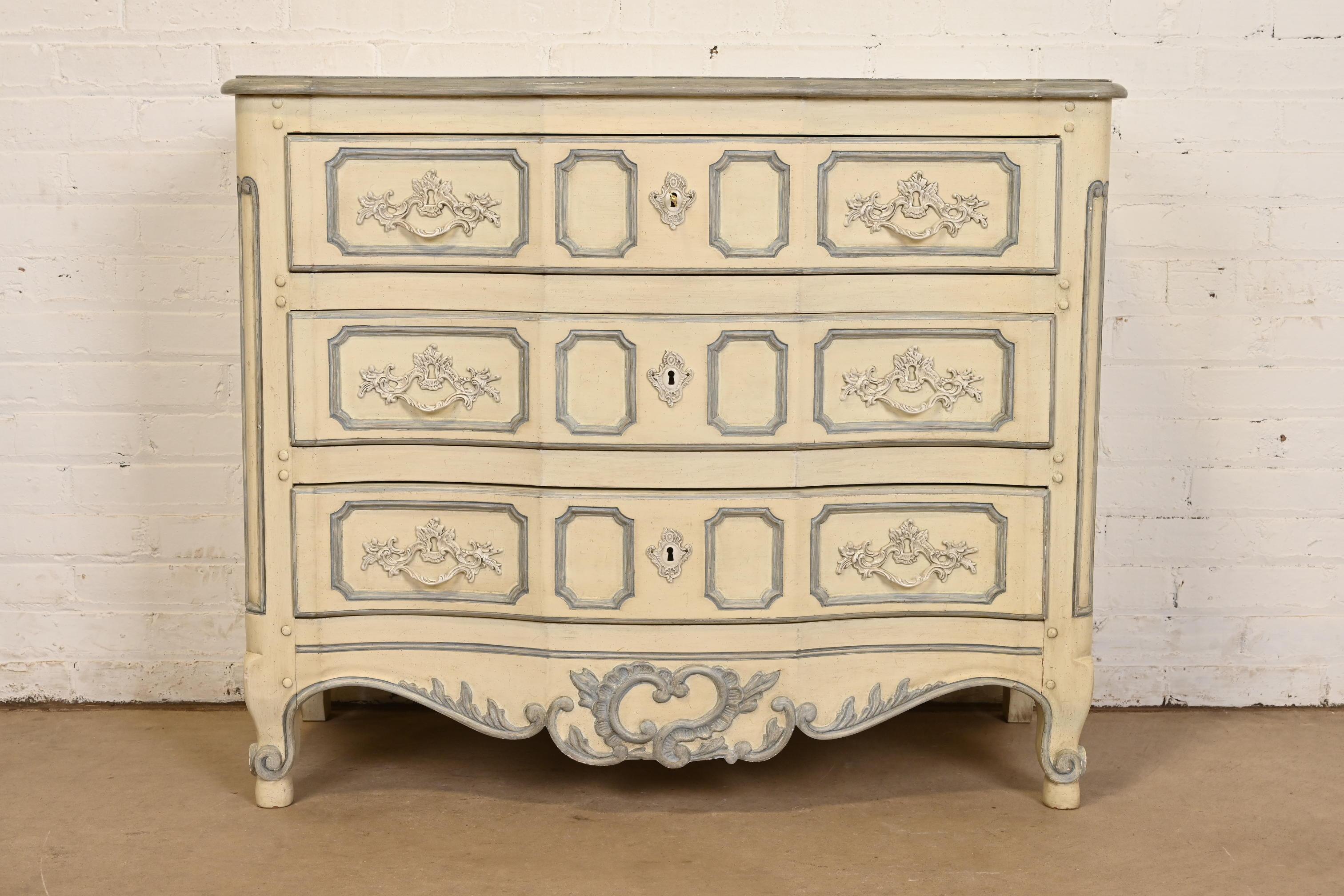 Uno splendido comò o cassettiera in stile French Country o French Provincial Luigi XV con fronte a serpentina

Da Baker Furniture

USA, circa anni '1960

Noce intagliato, con finitura originale laccata color crema e grigio blu. I cassetti si