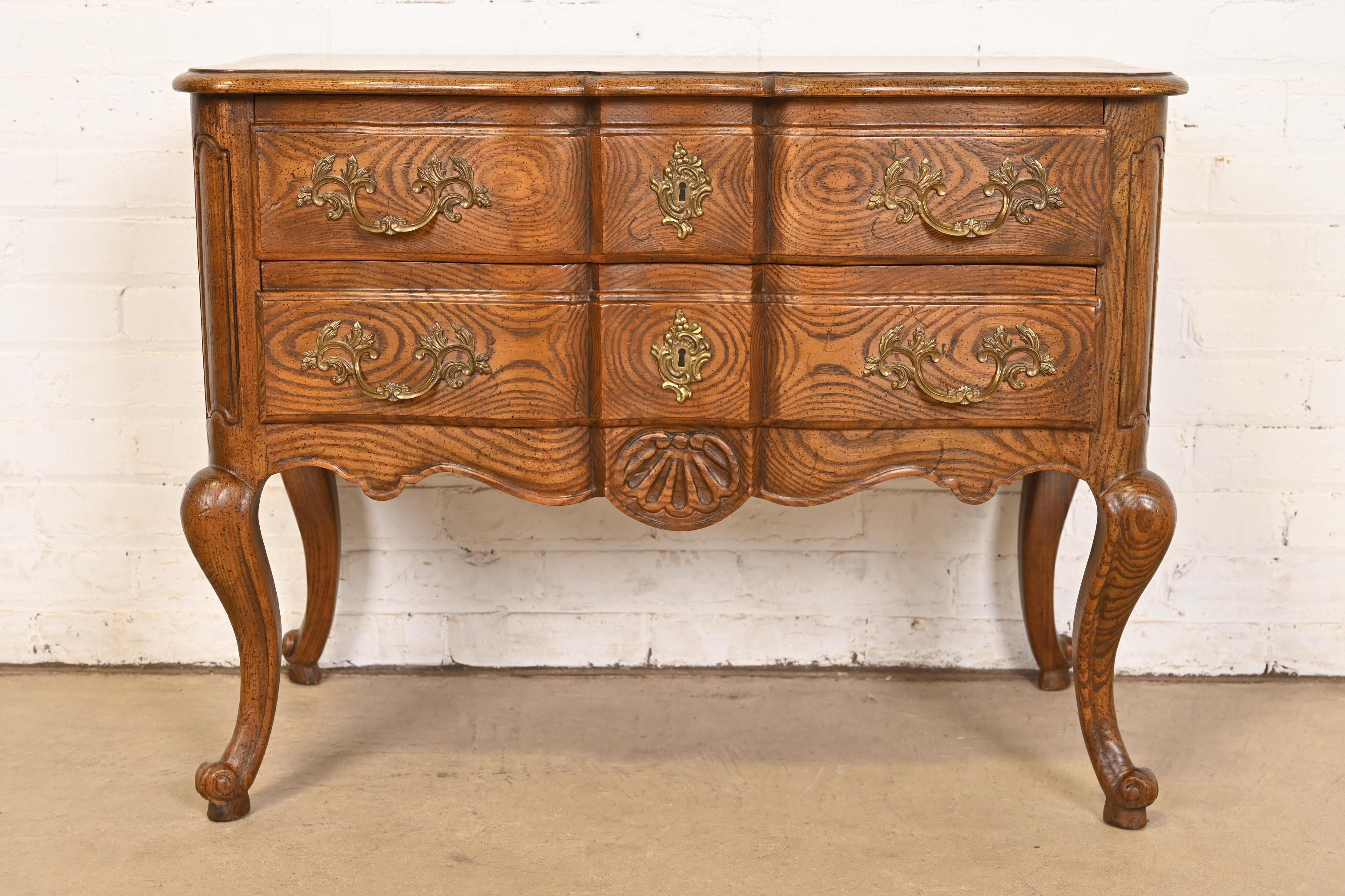 A gorgeous French Provincial Louis XV style commode, nightstand, or chest of drawers

By Baker Furniture

USA, Circa 1960s

Carved oak, with gorgeous book-matched burl wood top, and original brass hardware.

Measures: 32.38
