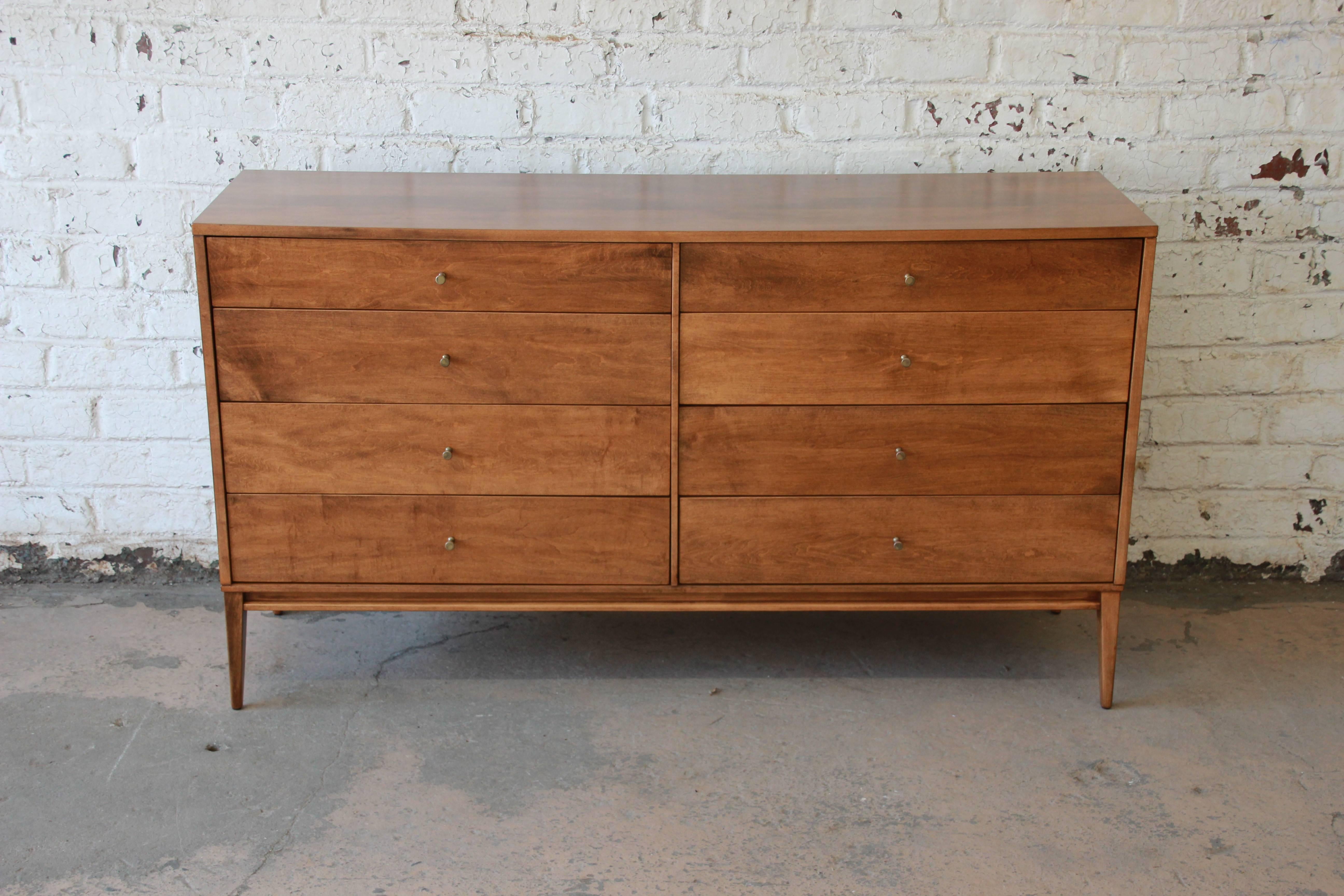 An exceptional eight-drawer dresser or credenza by iconic designer Paul McCobb for the Planner Group by Winchendon. The dresser features stunning wood grain and sleek Mid-Century lines. It is well constructed from solid maple and offers ample room