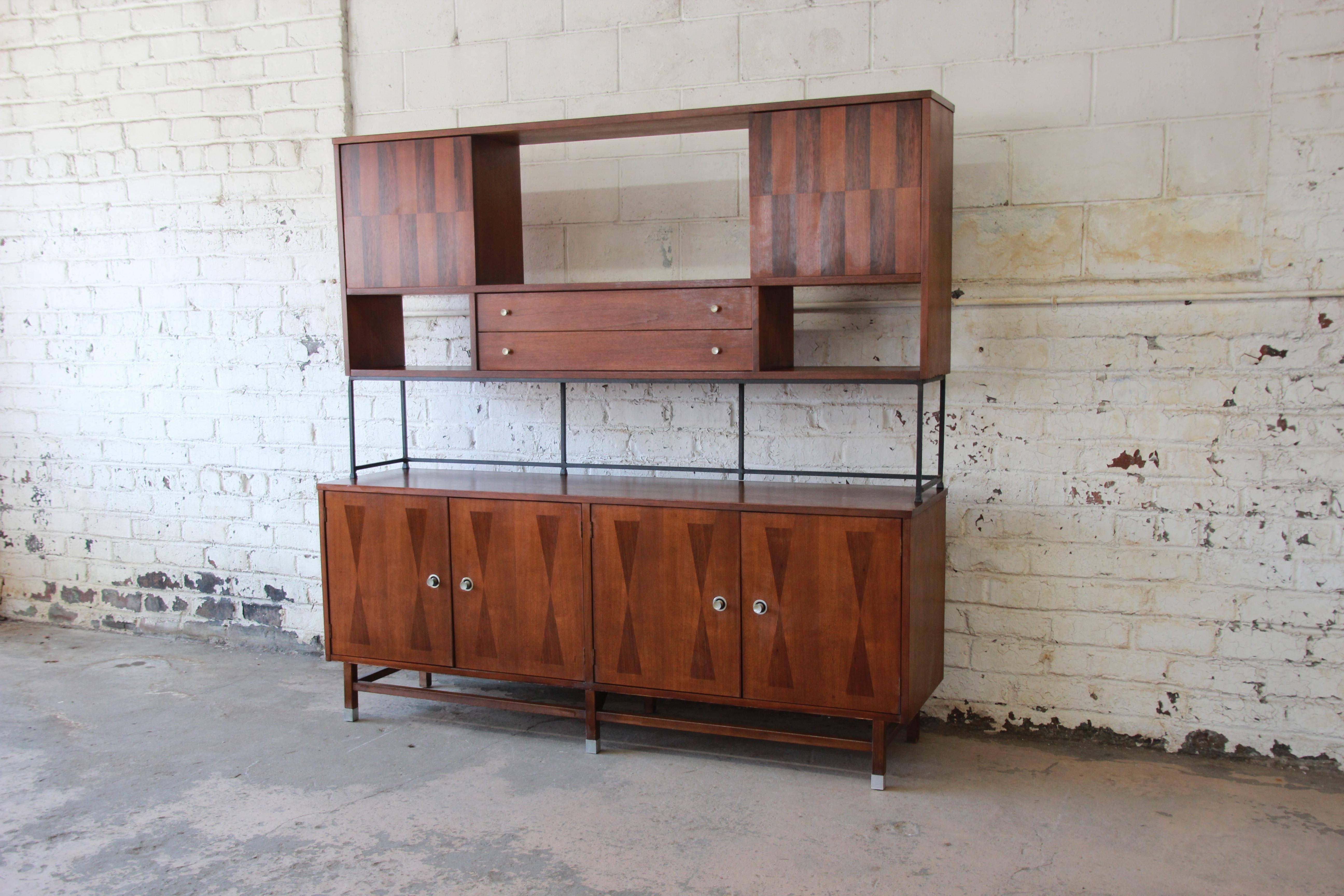 An exceptional Mid-Century Modern walnut and rosewood wall unit or sideboard by Stanley Furniture. The wall unit features gorgeous walnut wood grain with inlaid rosewood marquetry. It offers ample room for storage, with five dovetailed drawers and