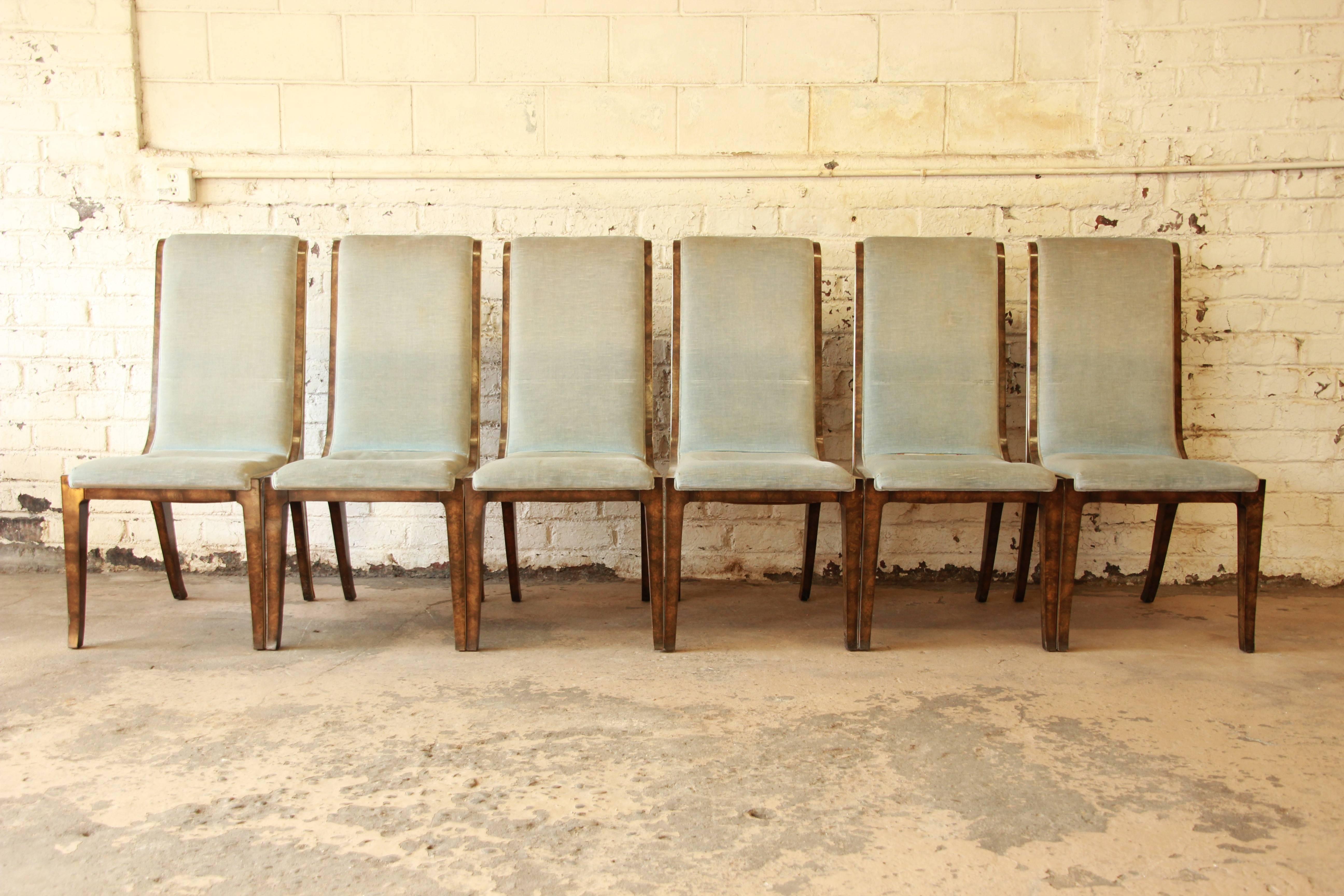 An outstanding set of six 1970s burl wood and brass dining chairs designed by William Doezema for Mastercraft. The chairs feature stunning burled Carpathian elm wood, with exquisite brass inlay and original light blue velvet upholstery. Excellent