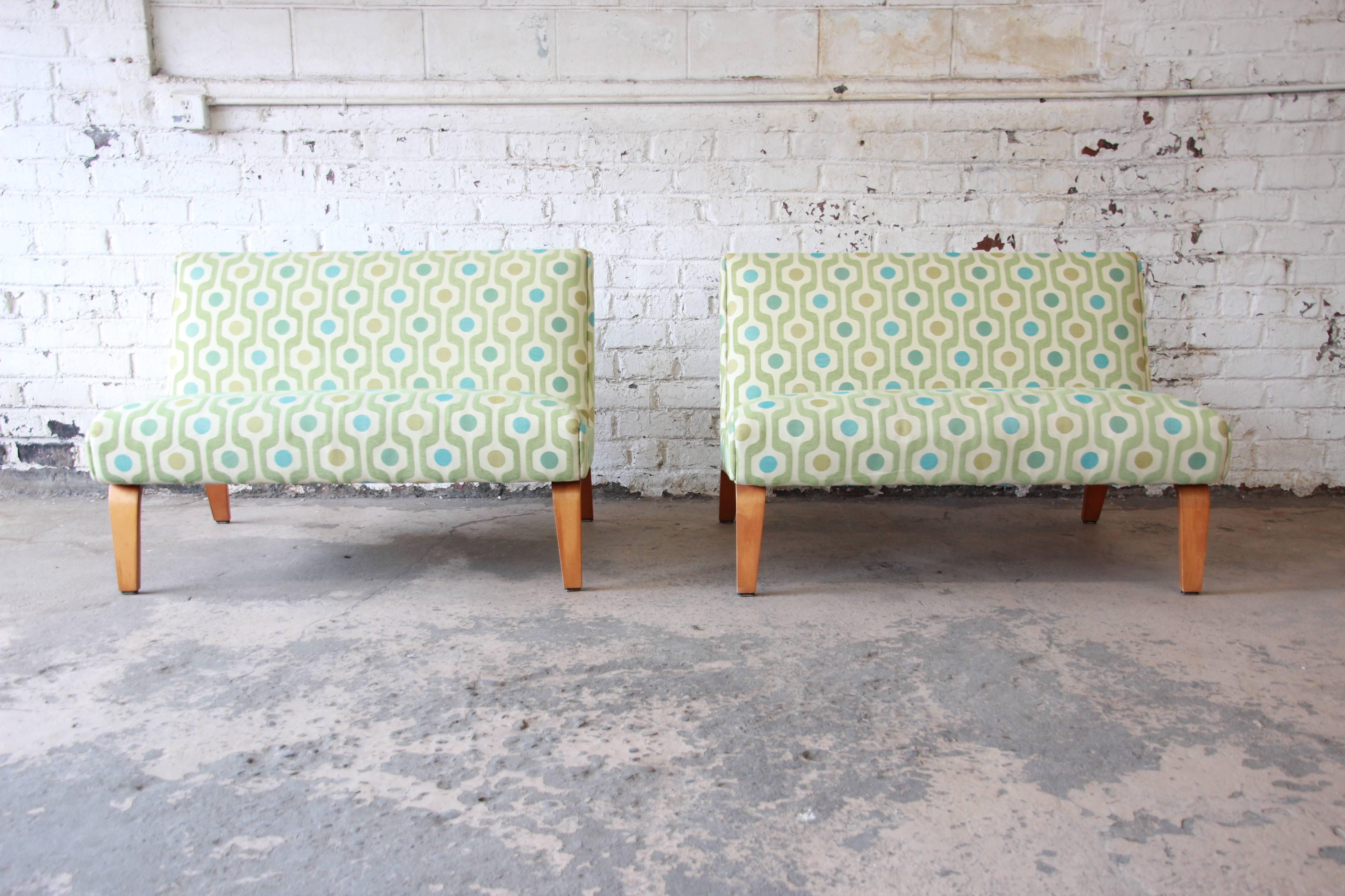 A fantastic pair of Mid-Century Modern bentwood settees by Thonet. The settees feature sleek and stylish Mid-Century design with unique bentwood legs. They have been reupholstered in a modern print within the past two years, and the upholstery is