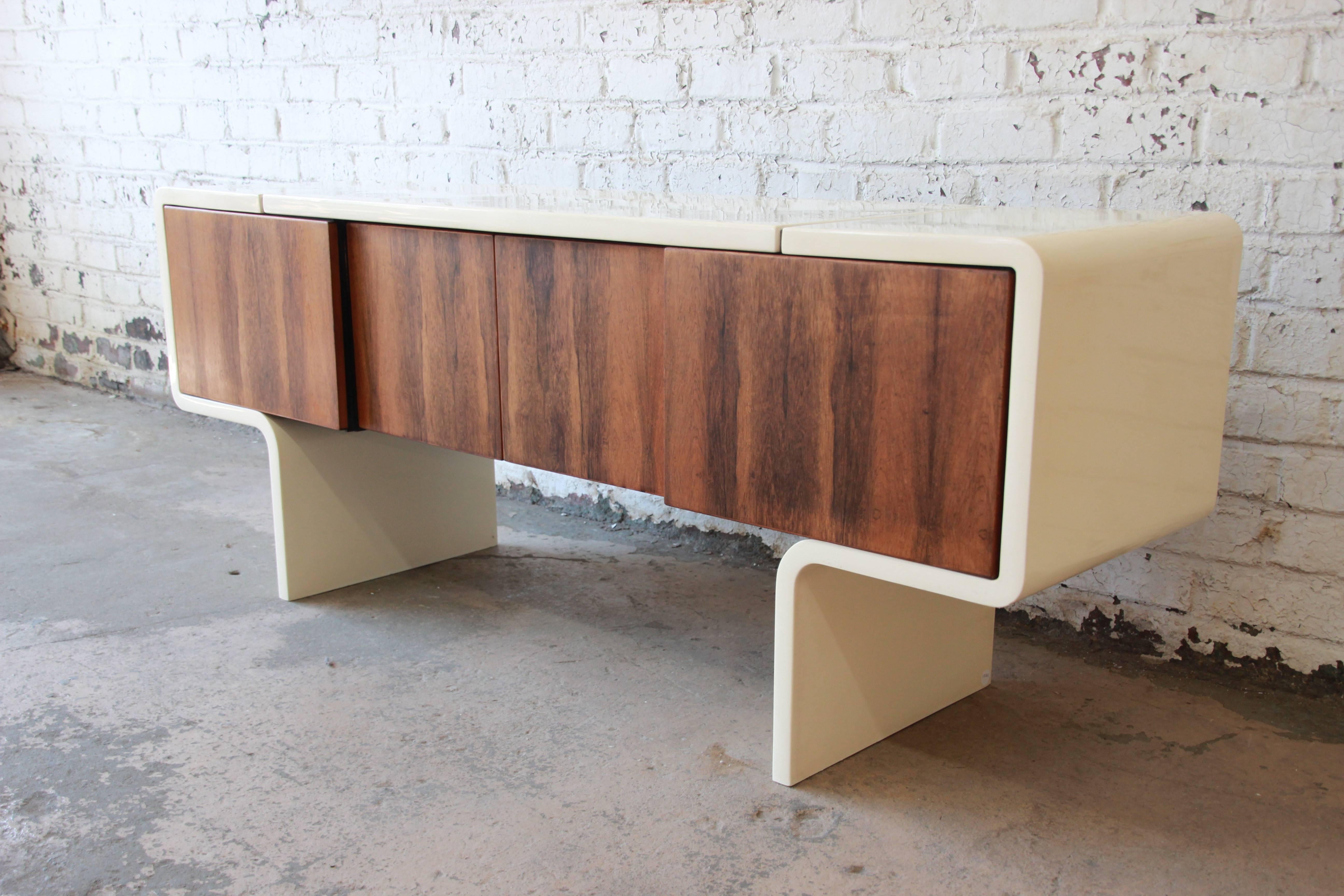 An exceptional and rare Mid-Century Modern uniplane credenza designed by William Sklaroff for Vecta, circa 1970s. The credenza features a stunning rosewood case, finished on both sides and supported by a reinforced lacquered fiberglass frame. The