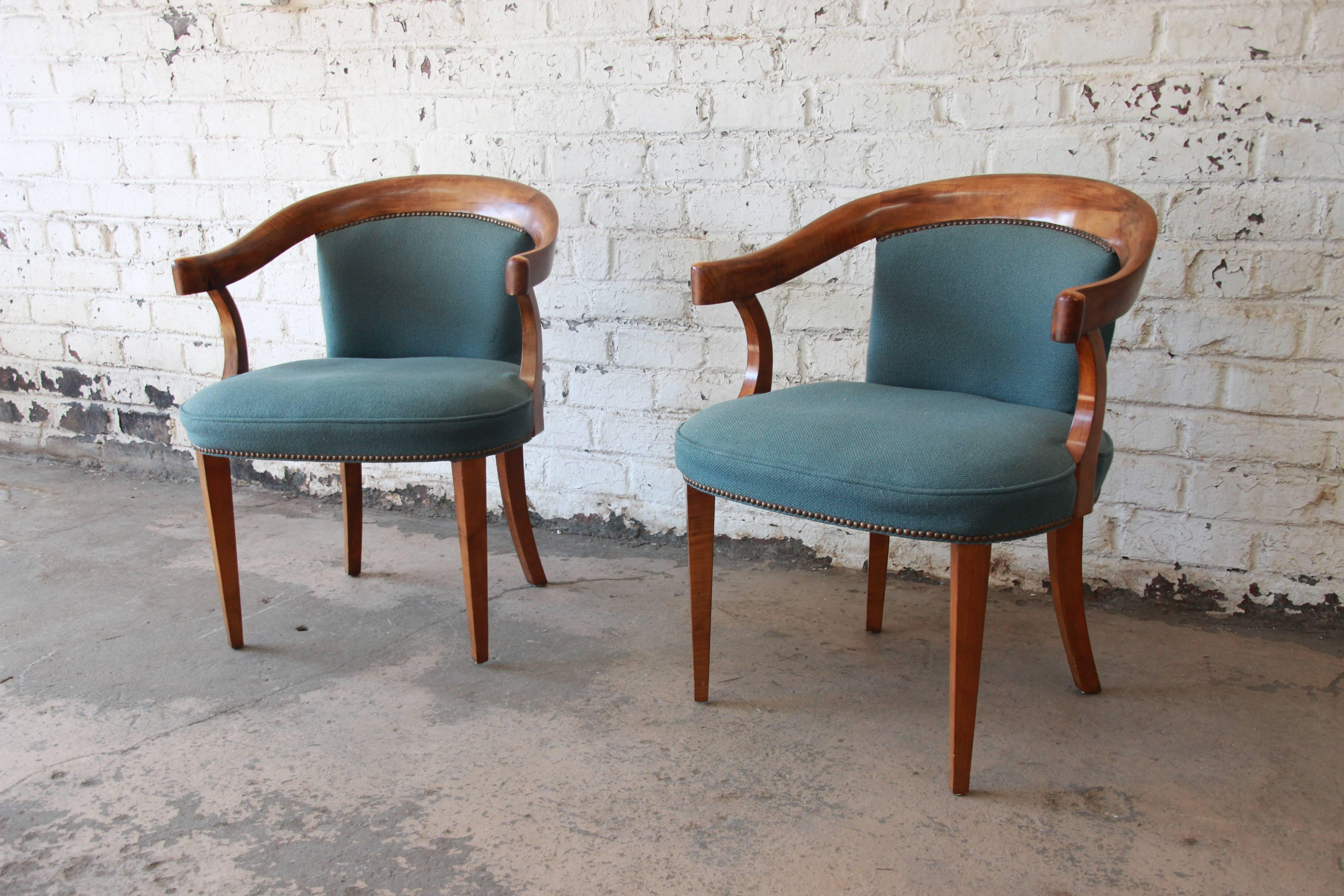 Stunning pair of Baker Furniture tiger maple armchairs. The chairs have a bentwood design and are made from solid maple with and clean studded upholstery. The chairs have an elegant design with tapered legs. The chairs have a firm seating and are