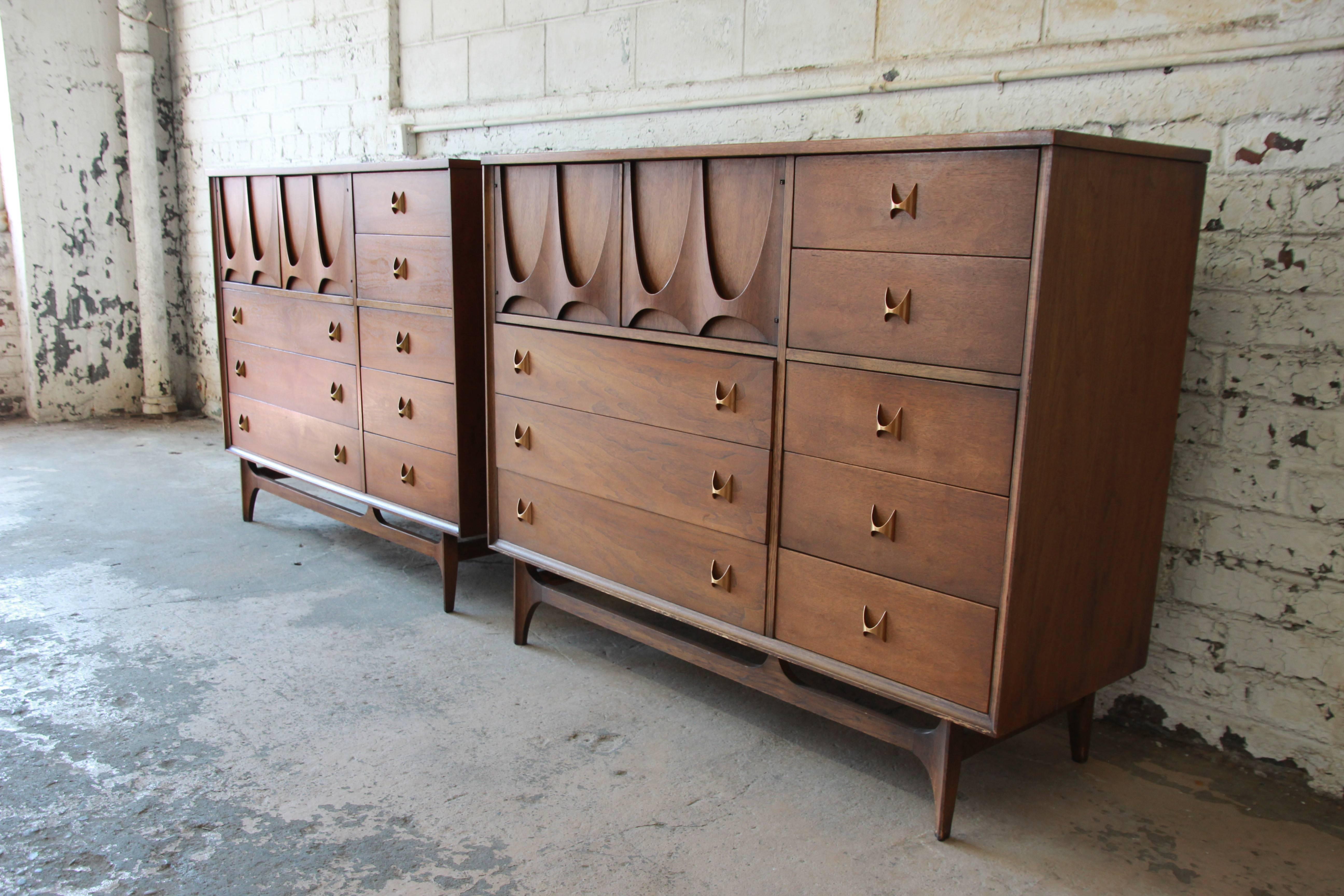 An outstanding Mid-Century Modern walnut highboy dresser or chest of drawers from the Broyhill Brasilia line, circa 1960s. The chest features eight dovetailed drawers with signature brass handles. Includes open storage with two dividers behind