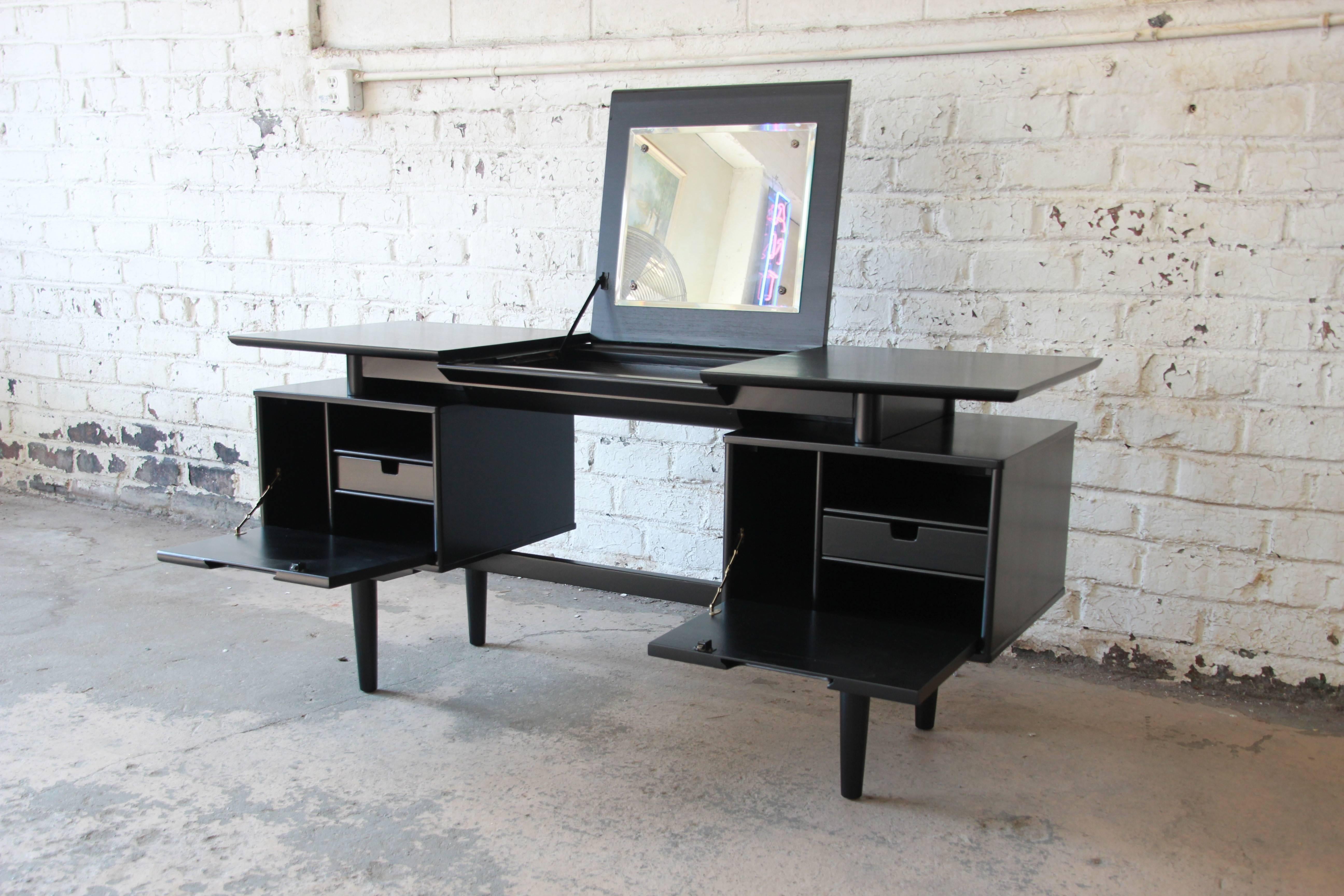 A rare and outstanding Mid-Century Modern floating top vanity desk designed by Milo Baughman for Drexel Furniture. The vanity features a stunning ebonized finish and sleek midcentury design. The rectangular top sits above two fitted compartments