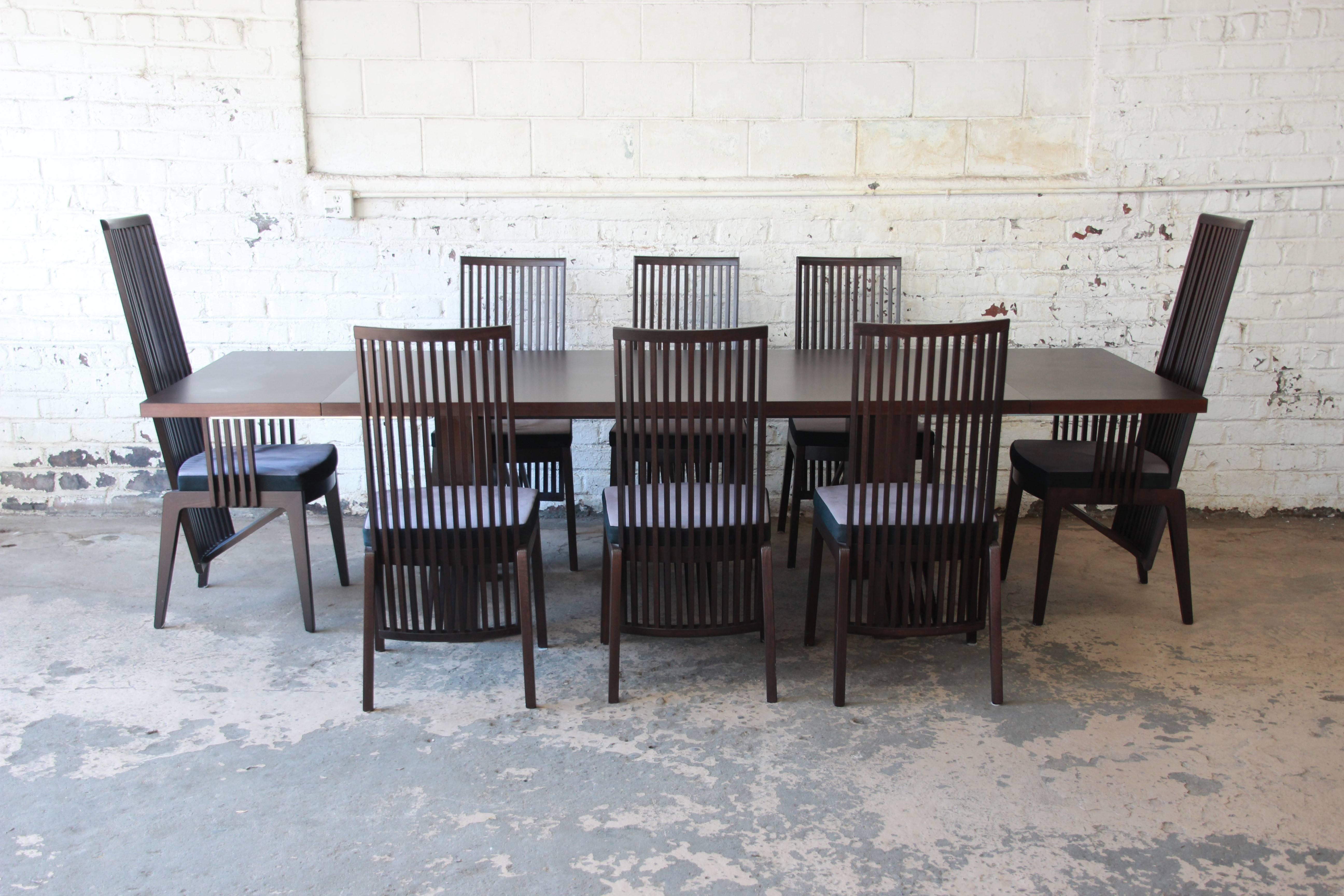 Offering an outstanding Frank Lloyd Wright style Arts & Crafts dining set made in Italy by A. Sibau. Included in the set is the table, two leaves, and eight high back chairs. Two of the chairs are captain chairs. The set features solid wood