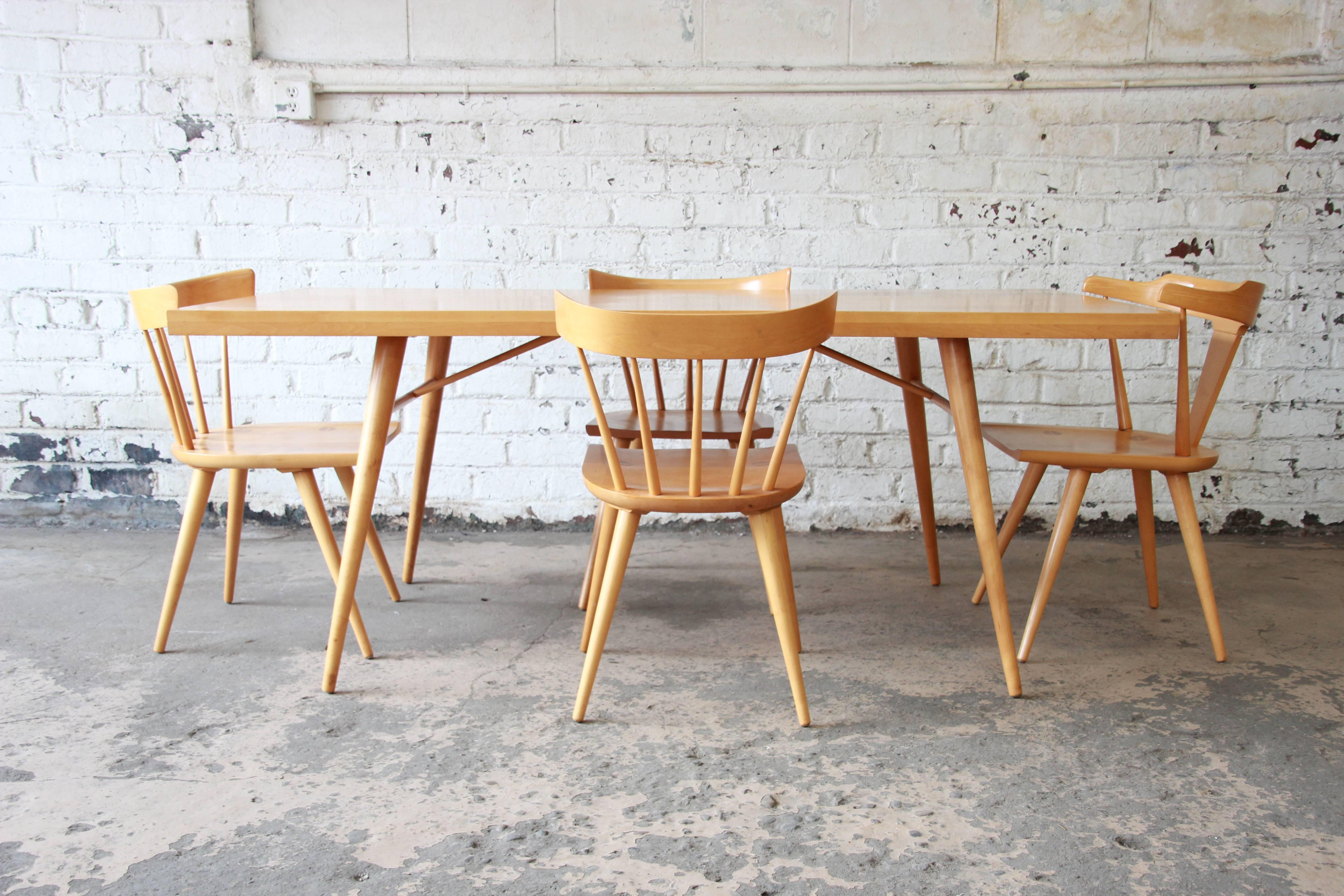 Offering a rare and exceptional Mid-Century Modern dining set designed by Paul McCobb for Winchendon Furniture. This original 1950s set includes the dining table and four chairs. There are three spindle back chairs and one T-back chair that serves