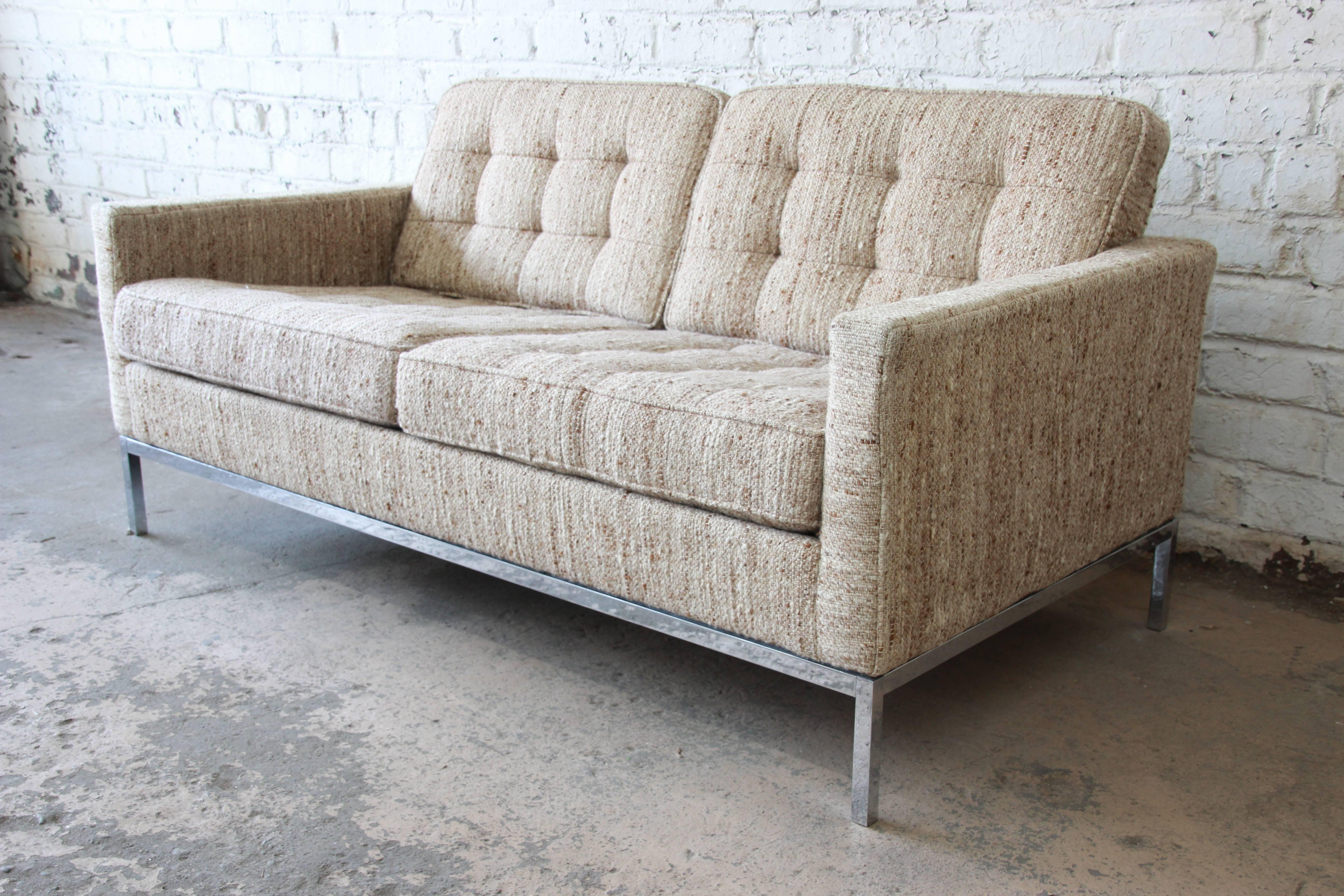 A stunning Mid-Century Modern loveseat sofa designed by Florence Knoll for Knoll International. The loveseat features a polished chrome base and the original multicolored wool upholstery in oatmeal, brown, and ivory. Stylish and comfortable, this is