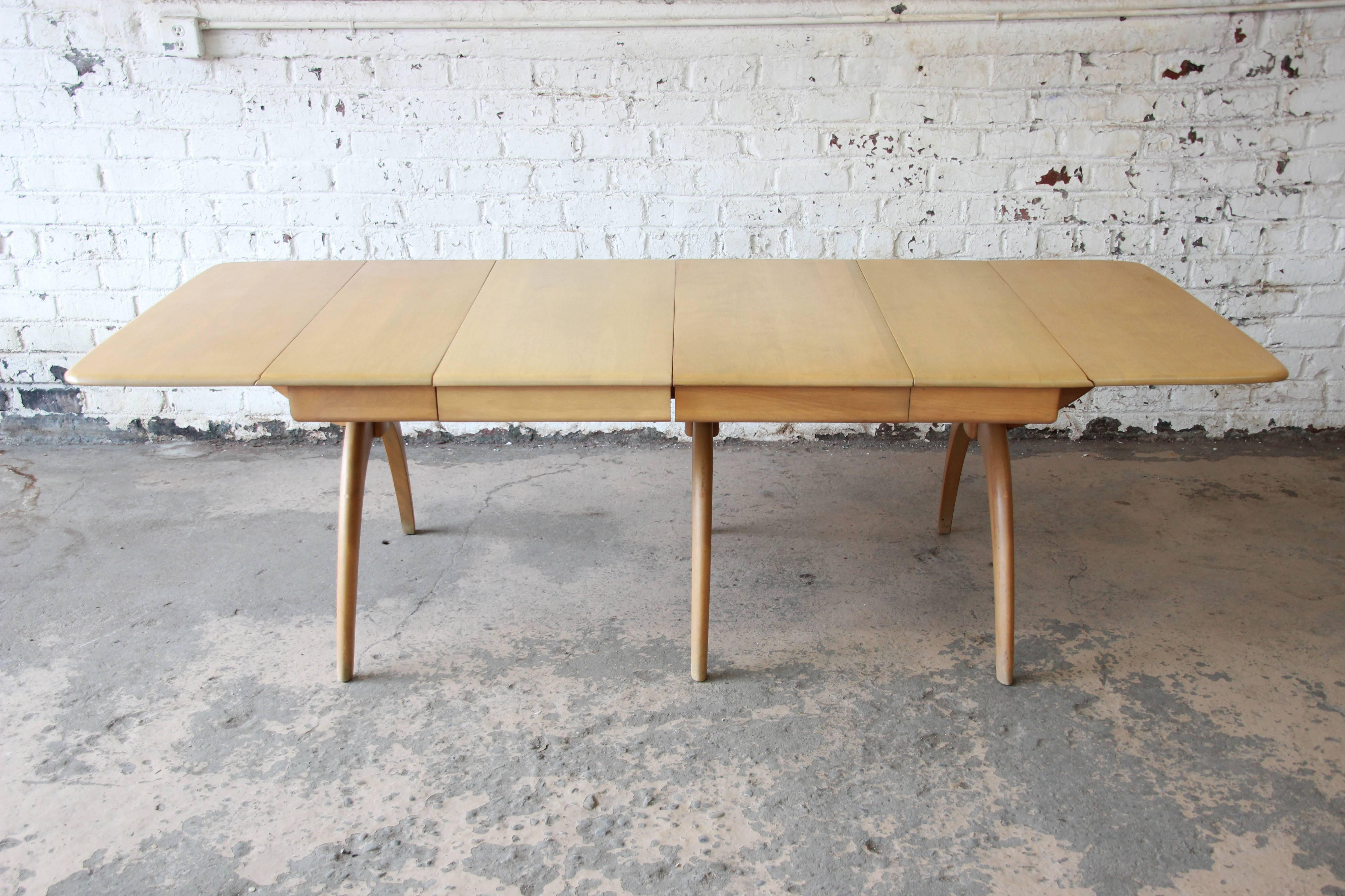 An exceptional Mid-Century Modern extension drop-leaf wishbone dining table by Heywood-Wakefield. The table is well constructed from solid maple and features sculpted 