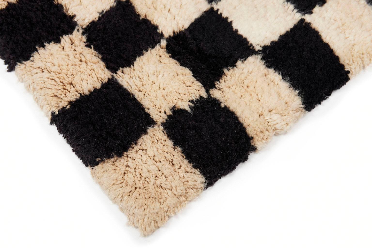 The ultimate rug for lounging, reading, or sleeping. The checkerboard black and white shag rug is hand-knotted with 100% high quality New Zealand wool. Super soft and plush with a Classic design. Designed by AELFIE.