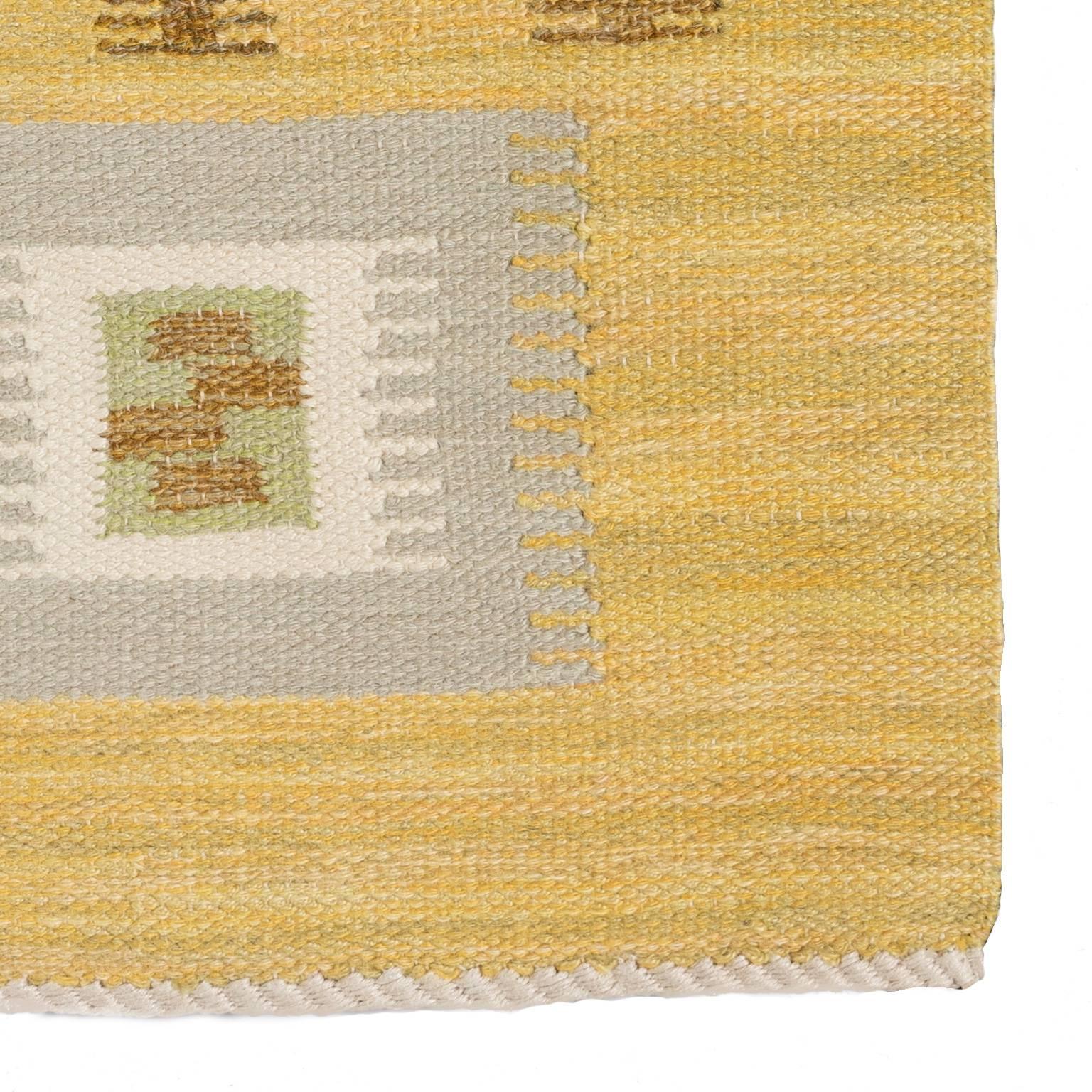 Geometric decor in Yellow, grey, green and brow tones. This rug is from Nk-textilkammare (NK-textile chamber) flat-woven Swedish rug executed in single interlocking tapestry technique. Signed NKT (Nk textile chamber) the department was lead by