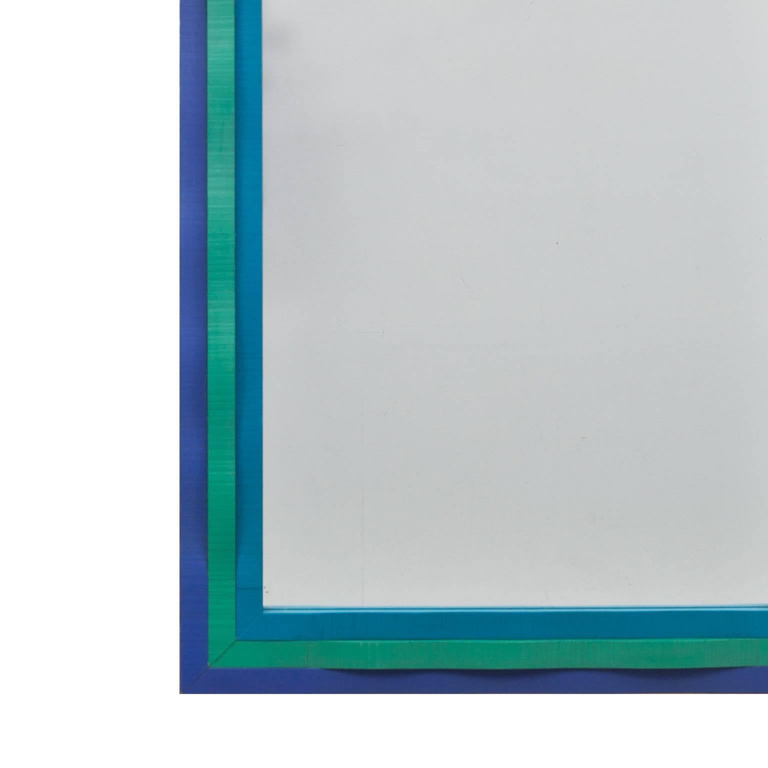 This mirror was manufactured i Eriksmåla in Sweden by the odd Swedish designer Erik Höglund who's often worked with artisanal forms. This frame are carved and has a wave pattern in relief. Painted in blue, green and turquoise shades. The mirror is