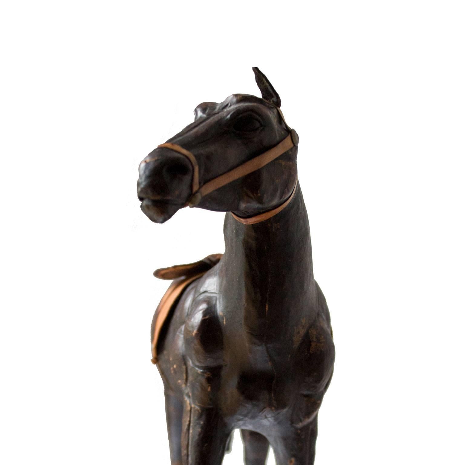 Wonderful interior accessories. This horse sculpture were likely produced circa mid-20th century in Italy. A vintage sculpture representing a horse wrapped in dark brown leather, with glass eyes. Beautiful vintage condition with appropriate patina.