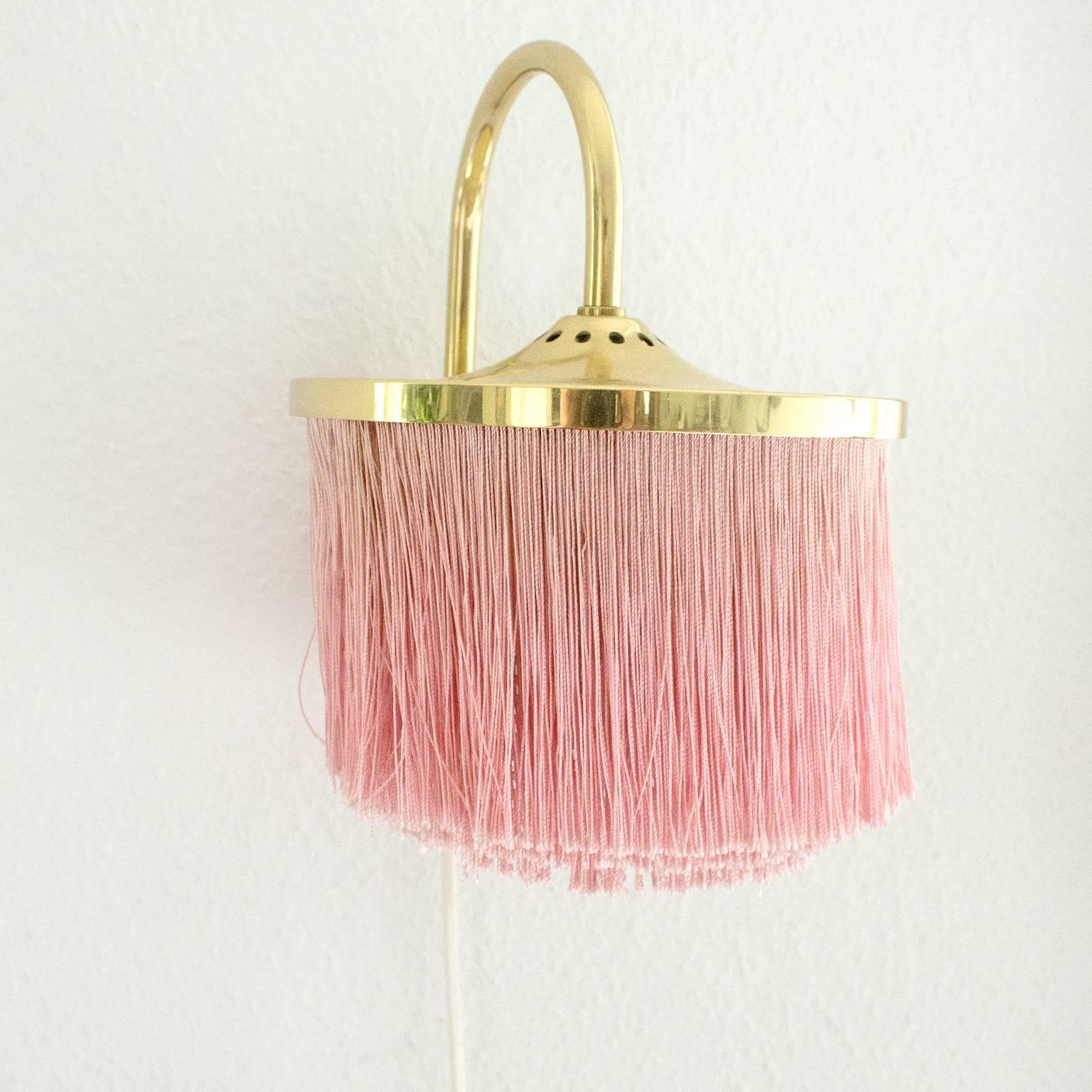 Brass and silk cord fringe wall light by Hans-Agne Jakobsson, Markaryd. Designed in Sweden, circa 1950s. Original cord and plug. Takes one E14 40w maximum bulb.