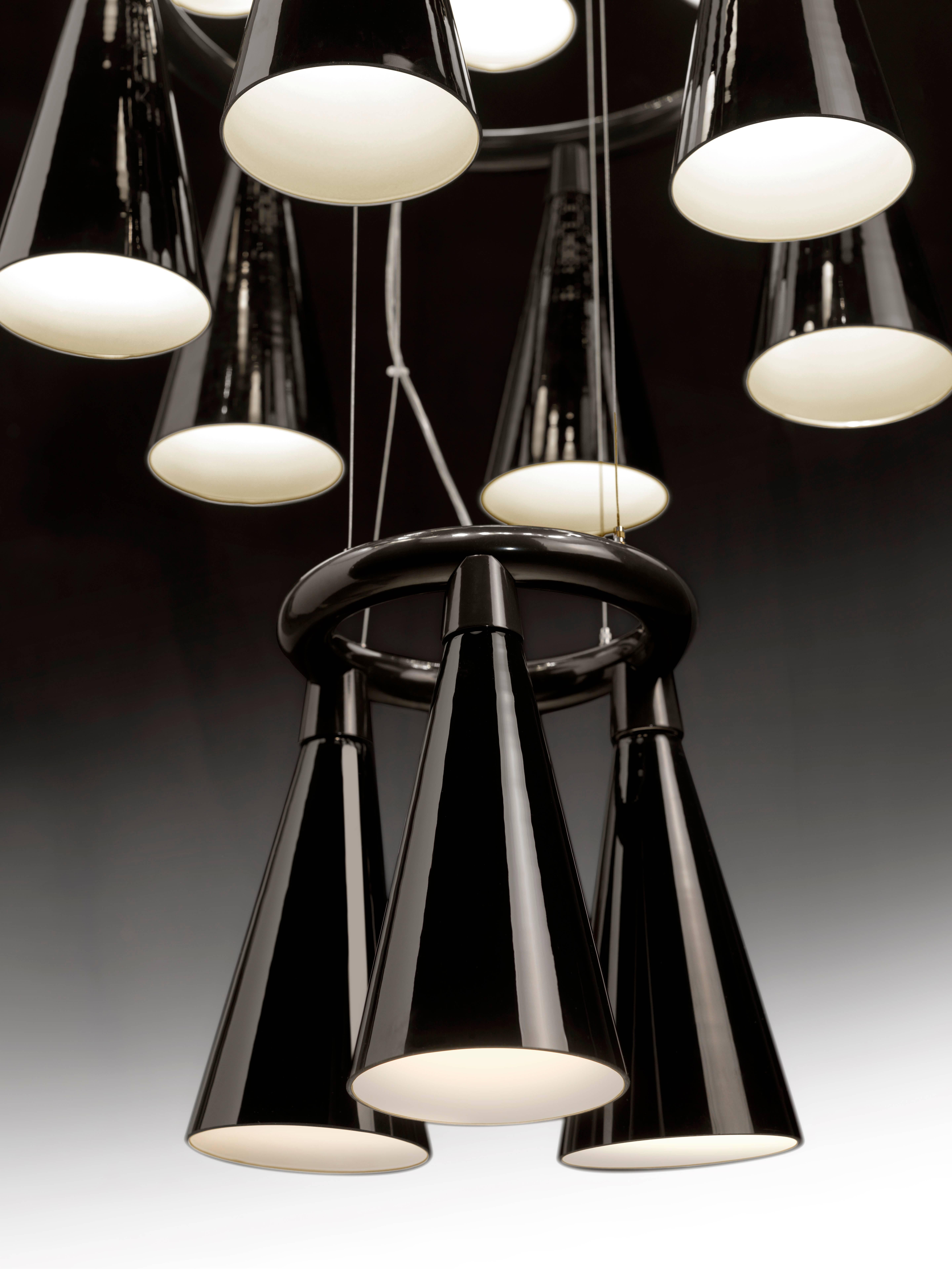 Komori: A chandelier reminiscent of a colony of bats hanging upside down from a tree branch or the ceiling of a cave. Evenly spaced glass shades blown by Murano glass artisans enclose LEDs, and cast their light downwards. Bases can be connected to