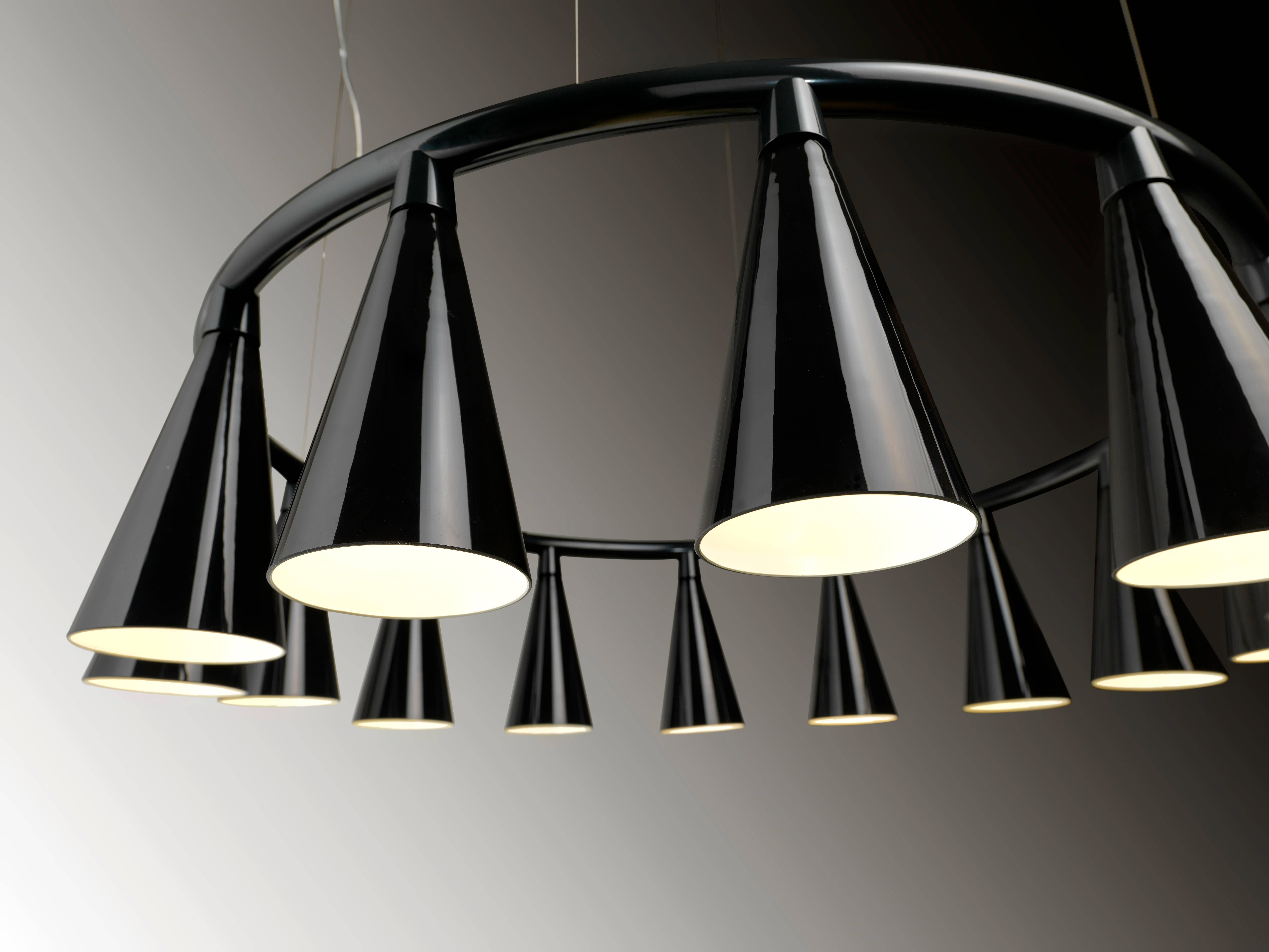 Komori: A chandelier reminiscent of a colony of bats hanging upside down from a tree branch or the ceiling of a cave. Evenly spaced glass shades blown by Murano glass artisans enclose LEDs, and cast their light downwards. Bases can be connected to