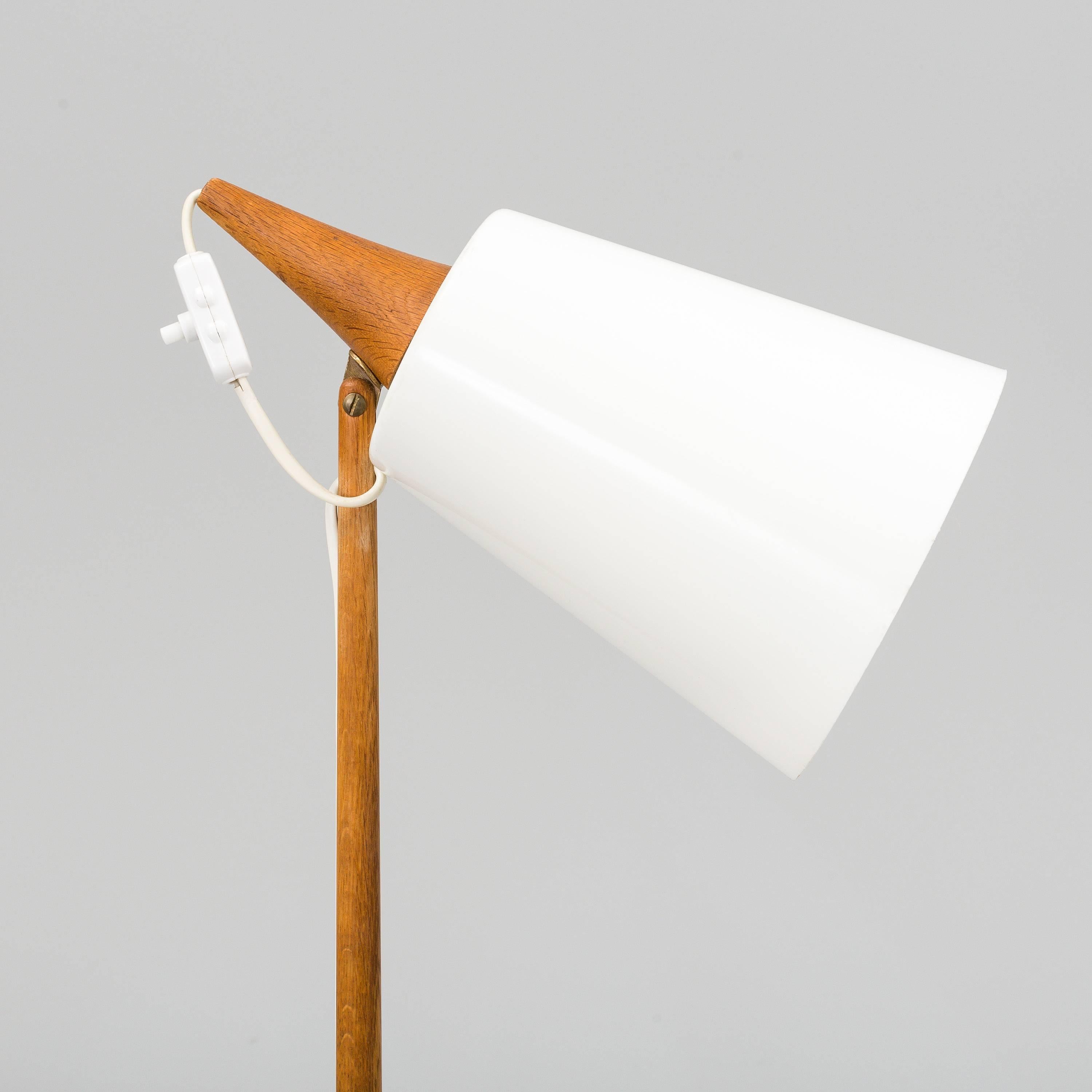 Scandinavian Modern floor lamp by Uno & Osten Kristiansson for Luxus, manufactured in Sweden in 1960s. Natural oak and white acrylic orientable shade. Signed in the bottom.