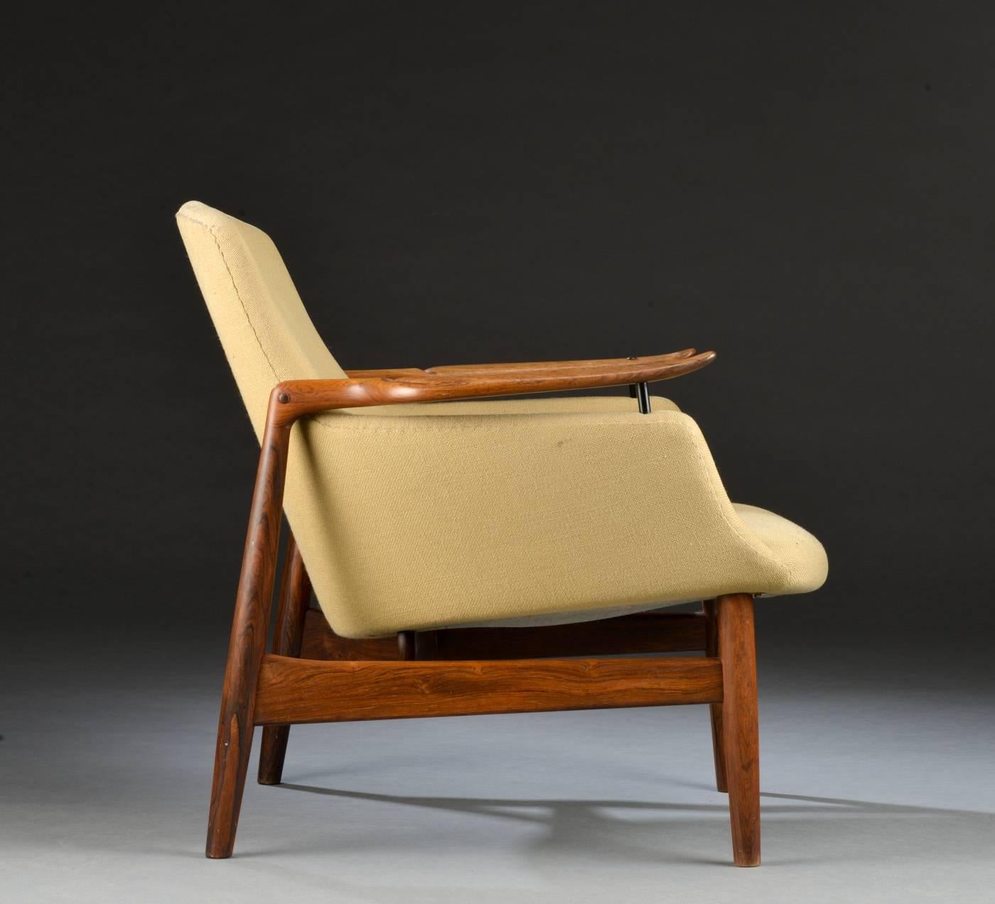 A rare easy chair in solid rosewood model FJ53 with floating armrest on brass fittings, upholstered with wool manufactured and stamped by Niels Vodder.
Designed in 1953 for Københavns Snedkerlaugs.