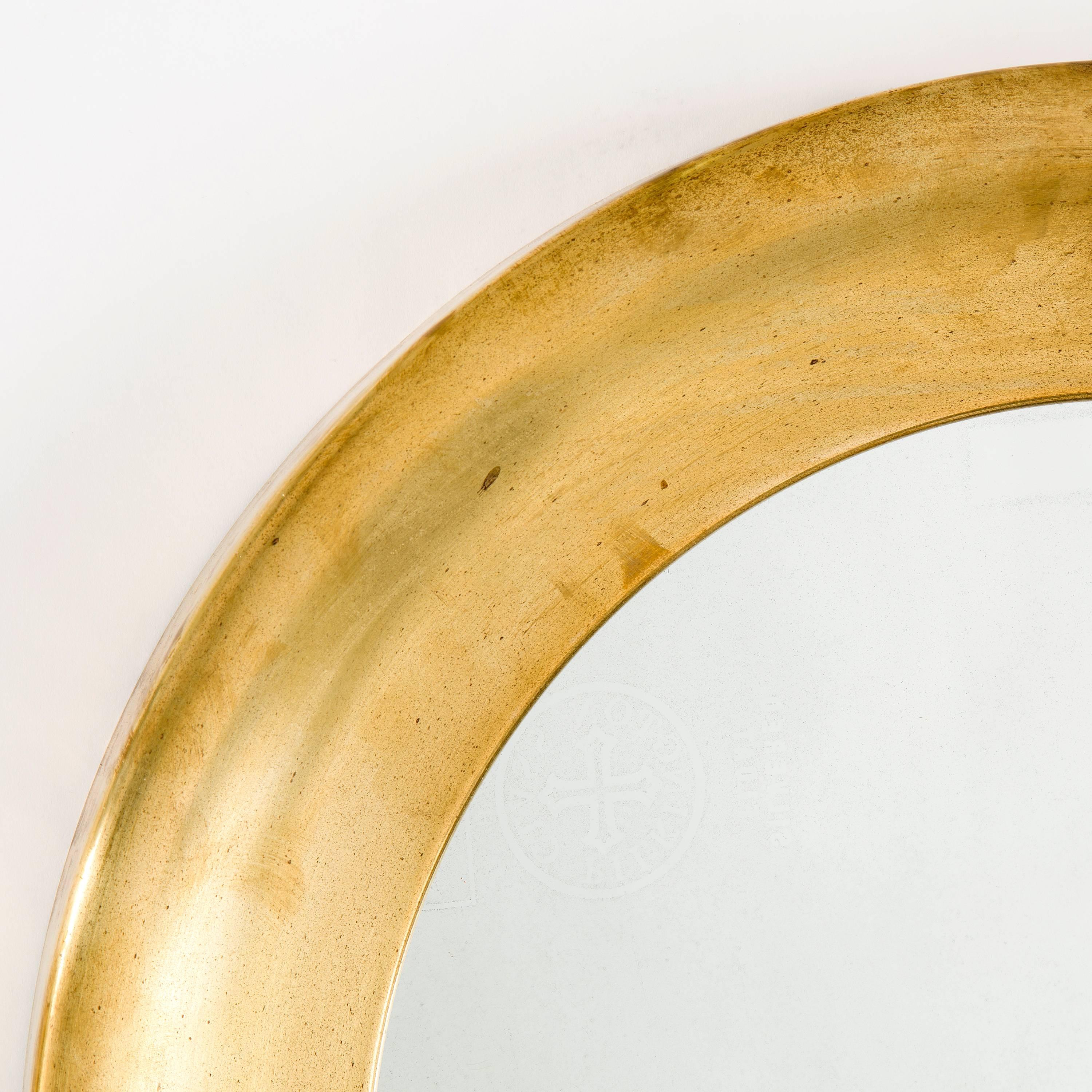 Swedish mid-20th century curved brass round mirror manufactured by Glas Master Markaryd. Beautiful vintage condition. Labeled in the back.