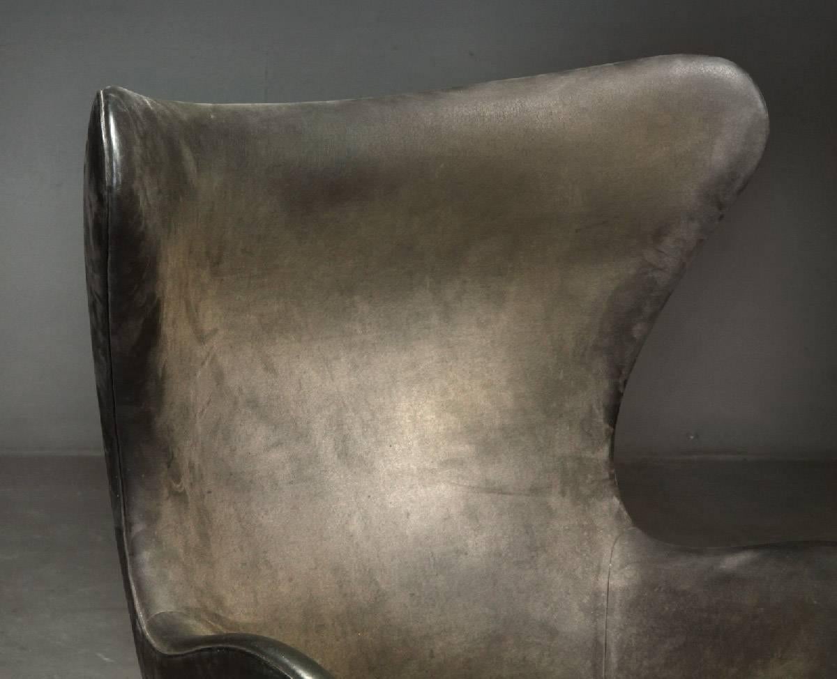 Early easy Egg chair model 3316 designed by Arne Jacobsen and produced by Fritz Hansen in Denmark in 1958. Vintage original upholstery with patinated dark brown/grey Nubuck leather. Tilt function. Signed by Fritz Hansen in the four-star foot.