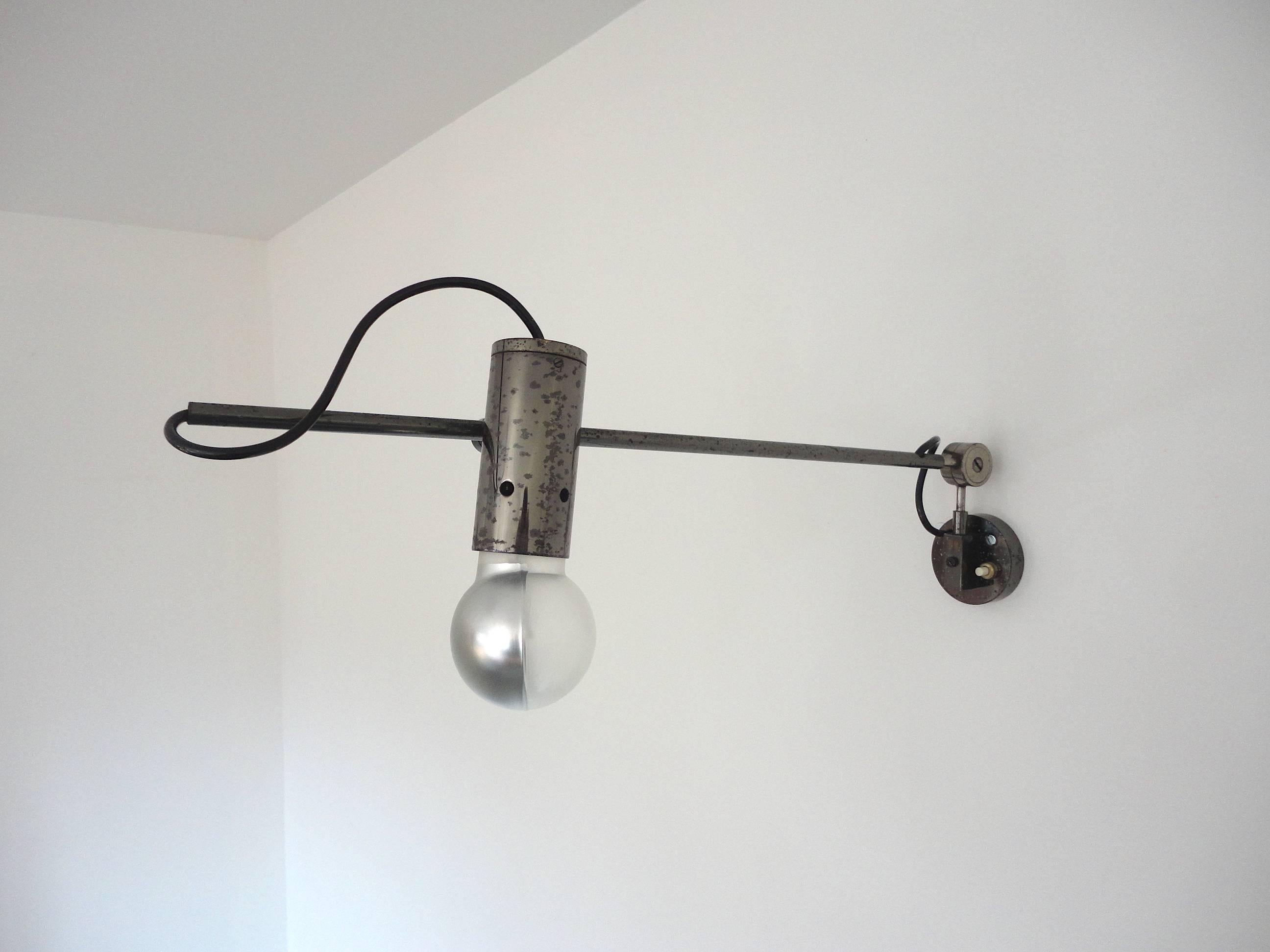 Fully original wall lamp designed in 1955 by Tito Agnoli and manufactured by Italian firm O-Luce. 

The lamp and the light bulb can be orientated in all directions and the lamp is made from unusual dark grey nickel plated metal and brass. 

The dark