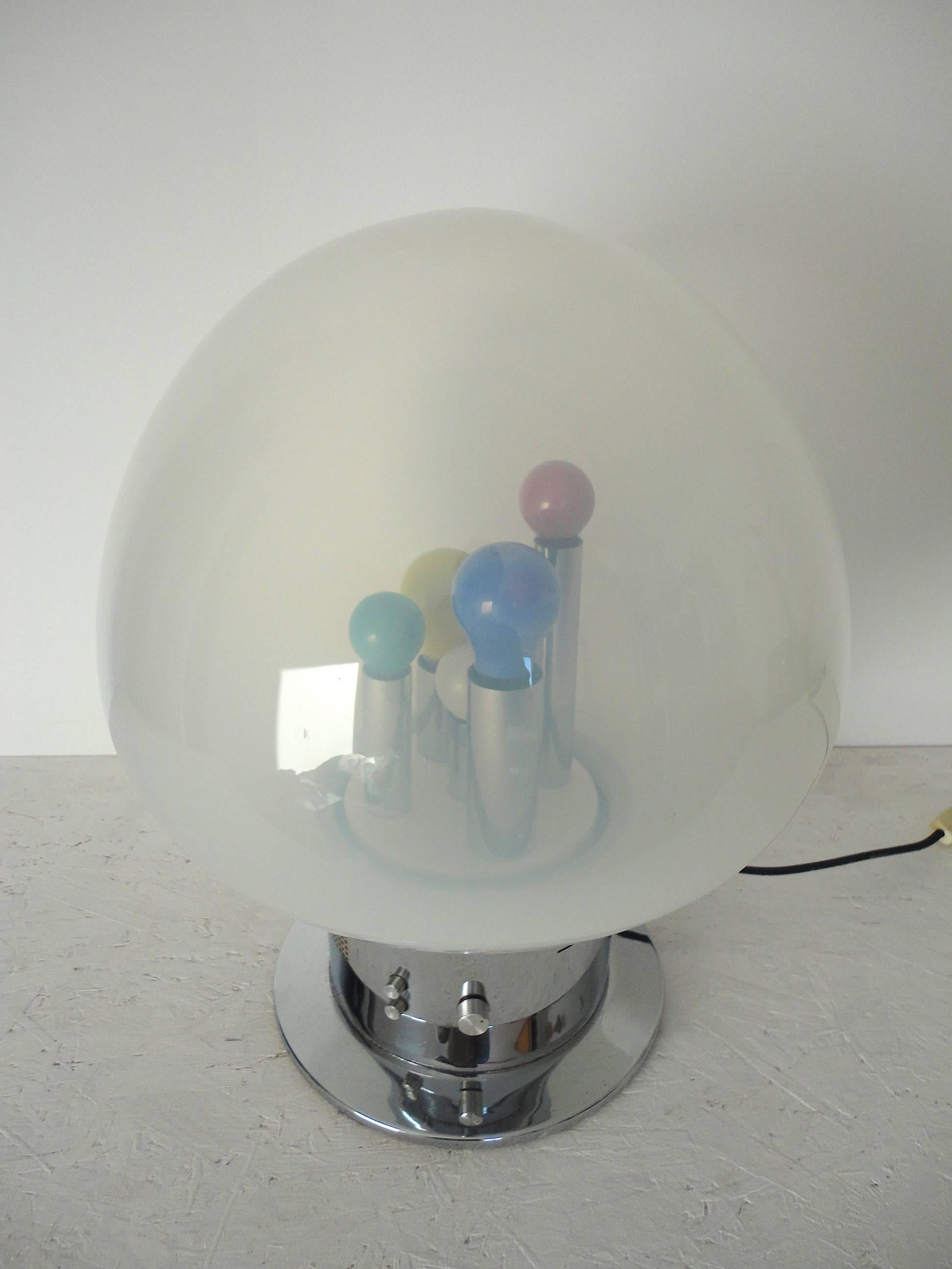 Large table lamp designed in the 1970s in Italy. It is made from chromed metal and handblown glass. The lamp has one natural and four colored lightbulbs, which can be used individually or together with the push of a button. The lamp also has a