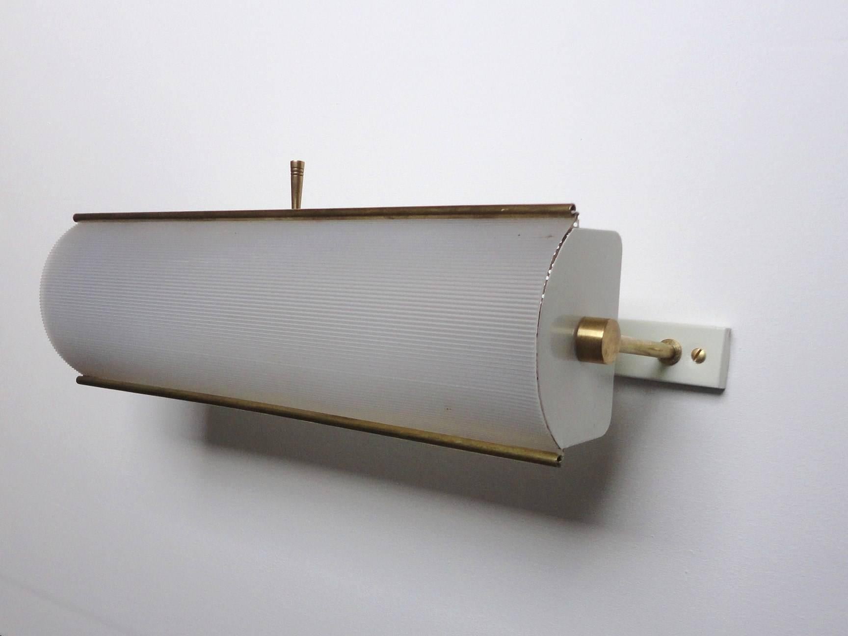 French Mid-Century wall lamps by Lunel.
circa 1955.
Made from brass, white lacquered metal and an acrylic reflector.
It features two B22 brass sockets and a push button switch on each lamp.
Those lamps are documented on Lunel adverts from the