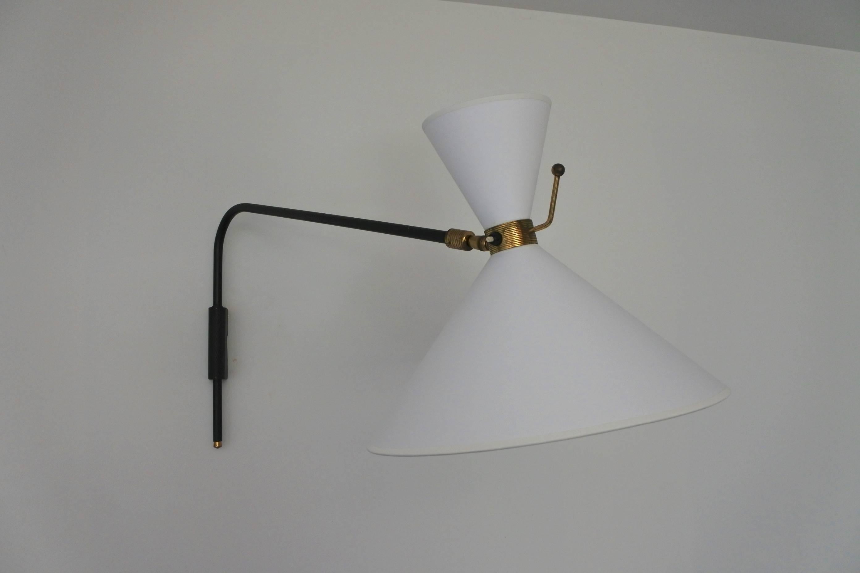 Swing arm and extensible wall lamp by French lighting manufacturer Arlus.
Made from lacquered tubular and perforated metal and brass.
The lamp features two independent switches and bulbs. 
The shade can be orientated in all directions.
The brass