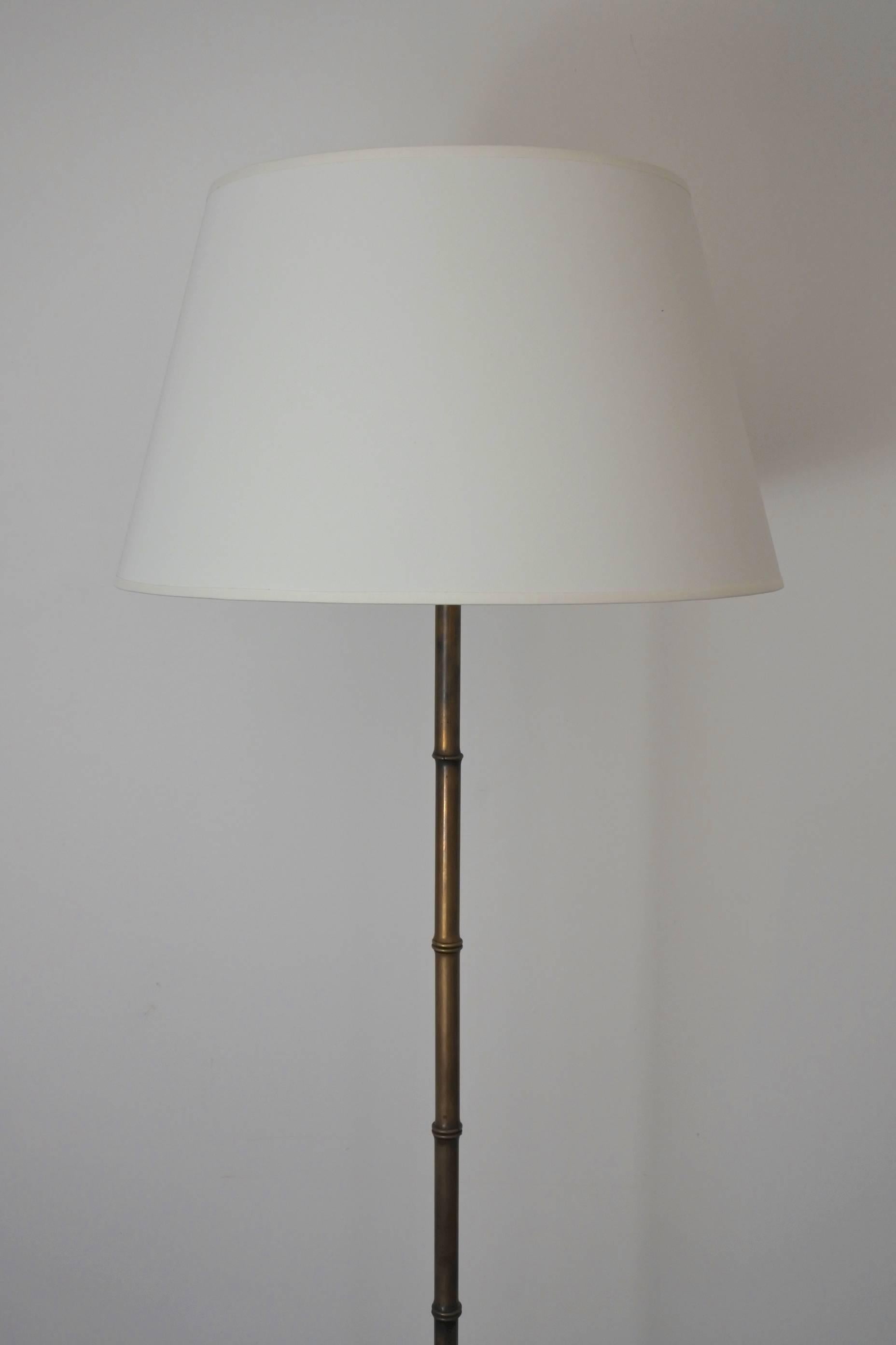 Midcentury faux bamboo floor lamp by french designer Jacques Adnet.
Solid brass stem, tripod base in forged iron with brass accents,
circa 1950.
Height silk shade included 170 cm (67 inches).