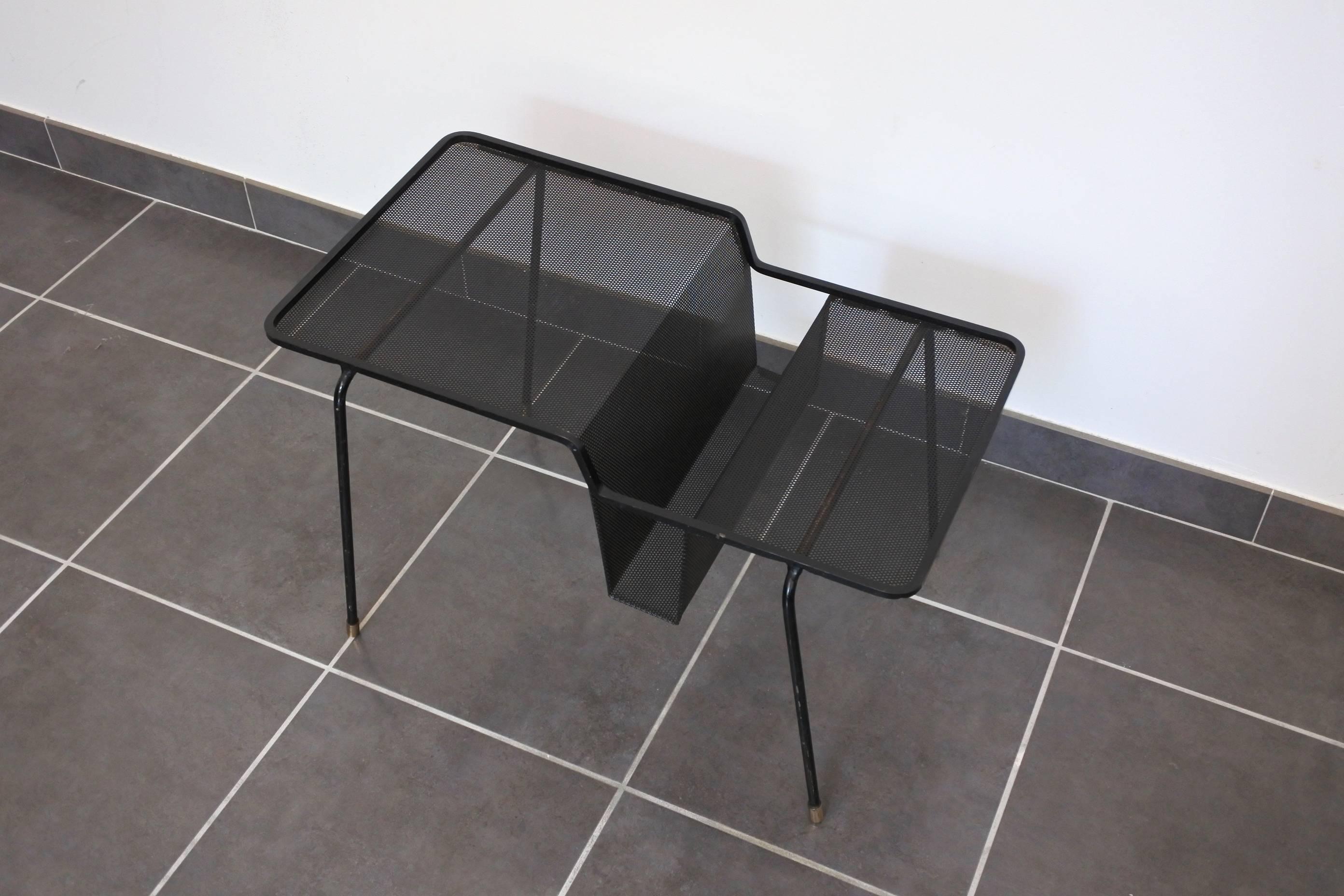 Mid-Century "Java" side table with a magazine holder by French designer Mathieu Mategot.
Black lacquered perforated and tubular metal, brass glides,
circa 1956.
Original lacquer.
The table is documented in the book "Mathieu