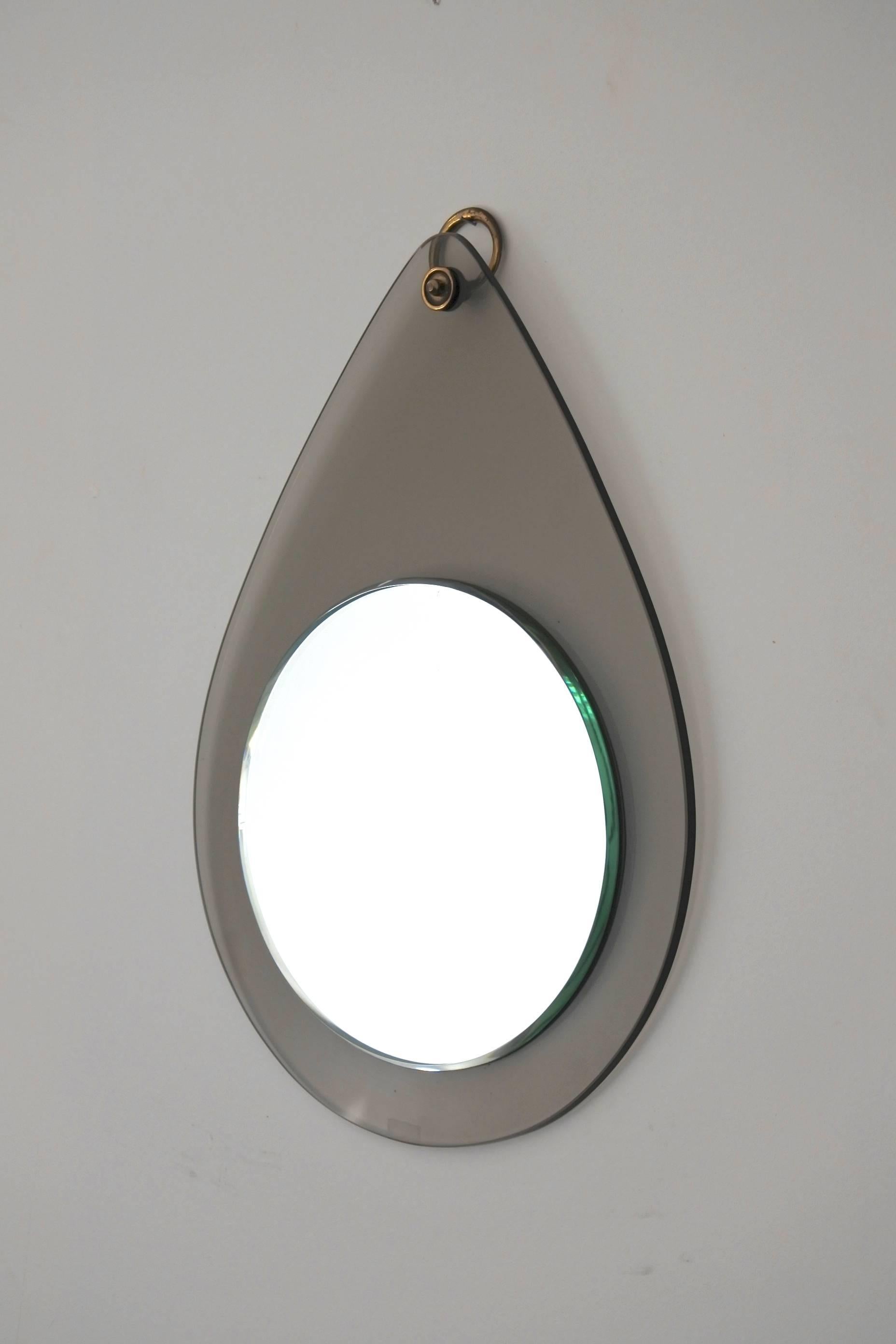 Midcentury Italian drop shaped glass mirror in the manner of Fontana Arte or Cristal Art.
It features a stylish brass hanging ring,
circa 1960.
Excellent condition.