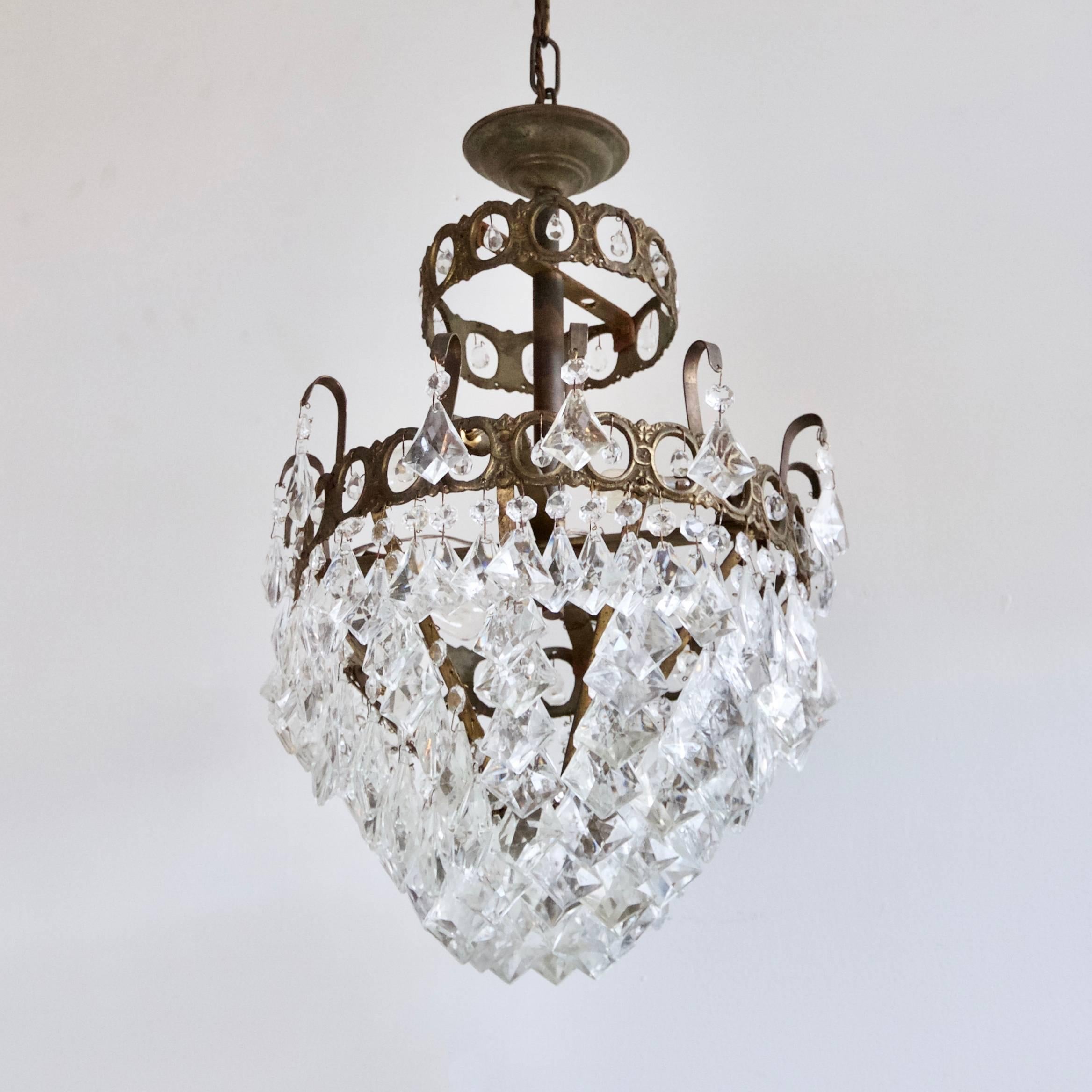 Petite French, 1920s brass chandelier dressed in glass kite drops and small contemporary crystal details. Chandelier uses four SBC, B15 fittings. Supplied with chain and ceiling rose.