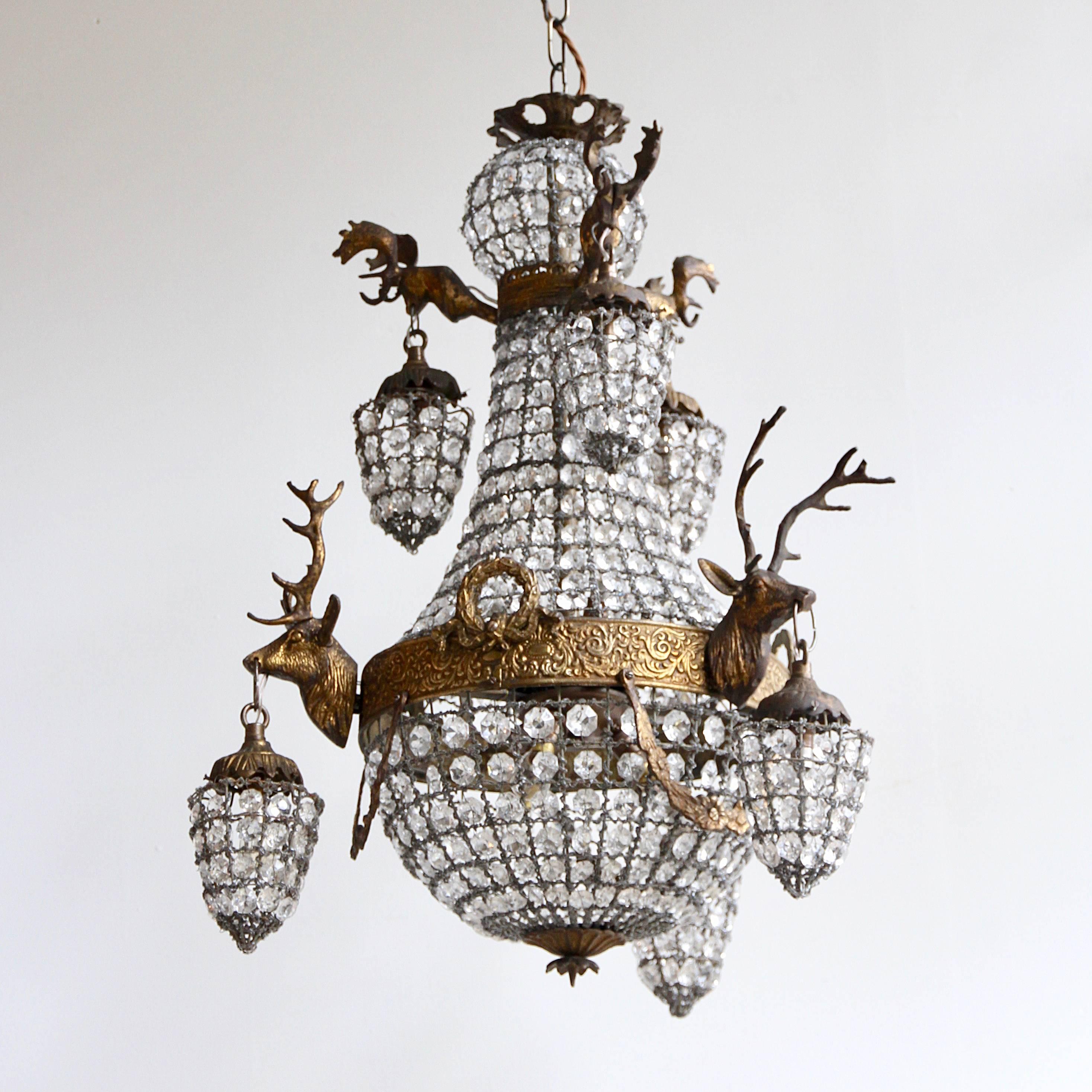 Early 1900s French Empire balloon chandelier with stags head sconces. Parts of the glass encrusted mesh have been restored and replaced. Chandelier has six hidden inner lamps and six outer lanterns all containing a single lamp. Supplied with chain