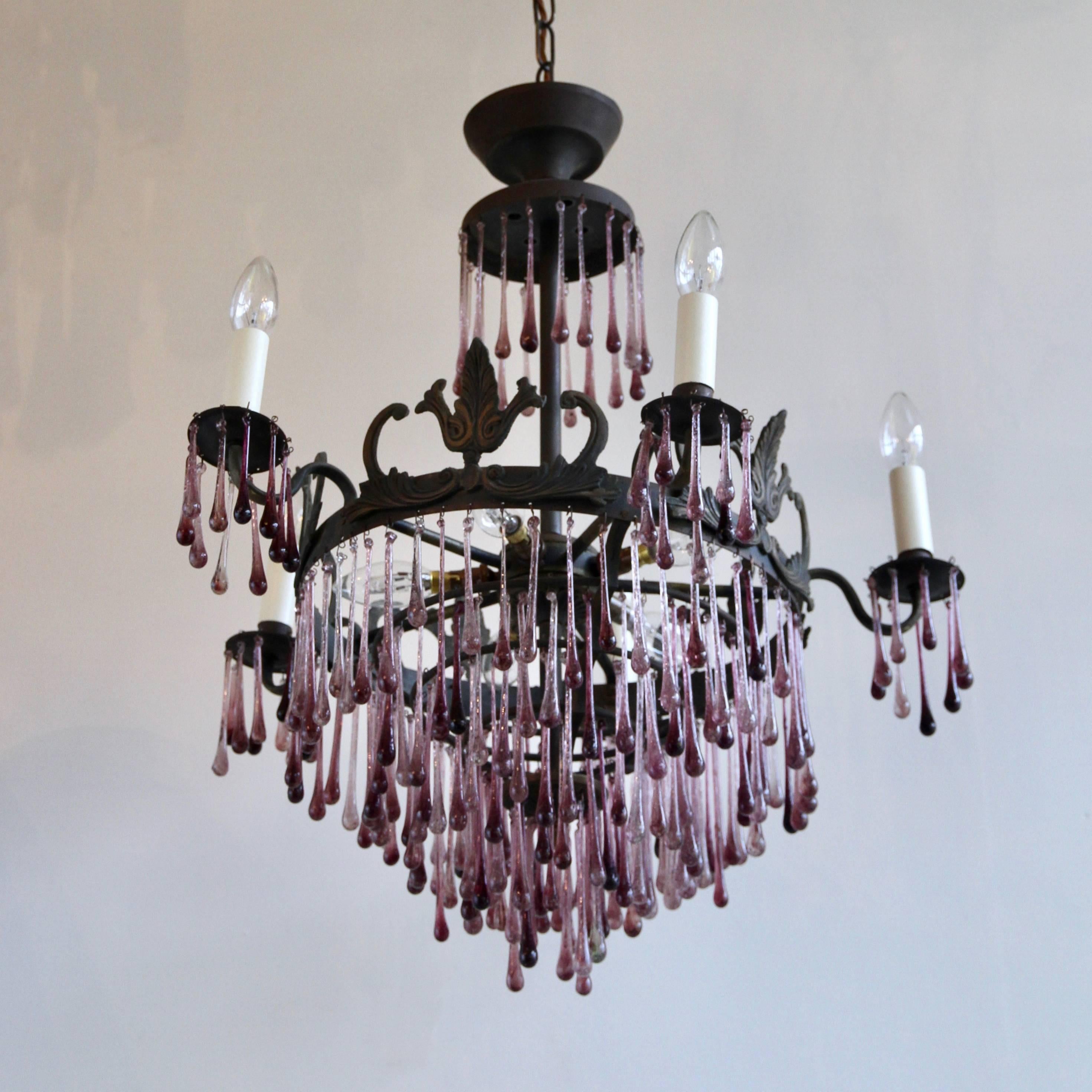 1920s French ornate waterfall chandelier frame dressed in striking contemporary amethyst glass teardrops. This light would provide a bold injection of color as it is still impactful even when unlit. It has a total of ten lamps, fiver SBC inner and