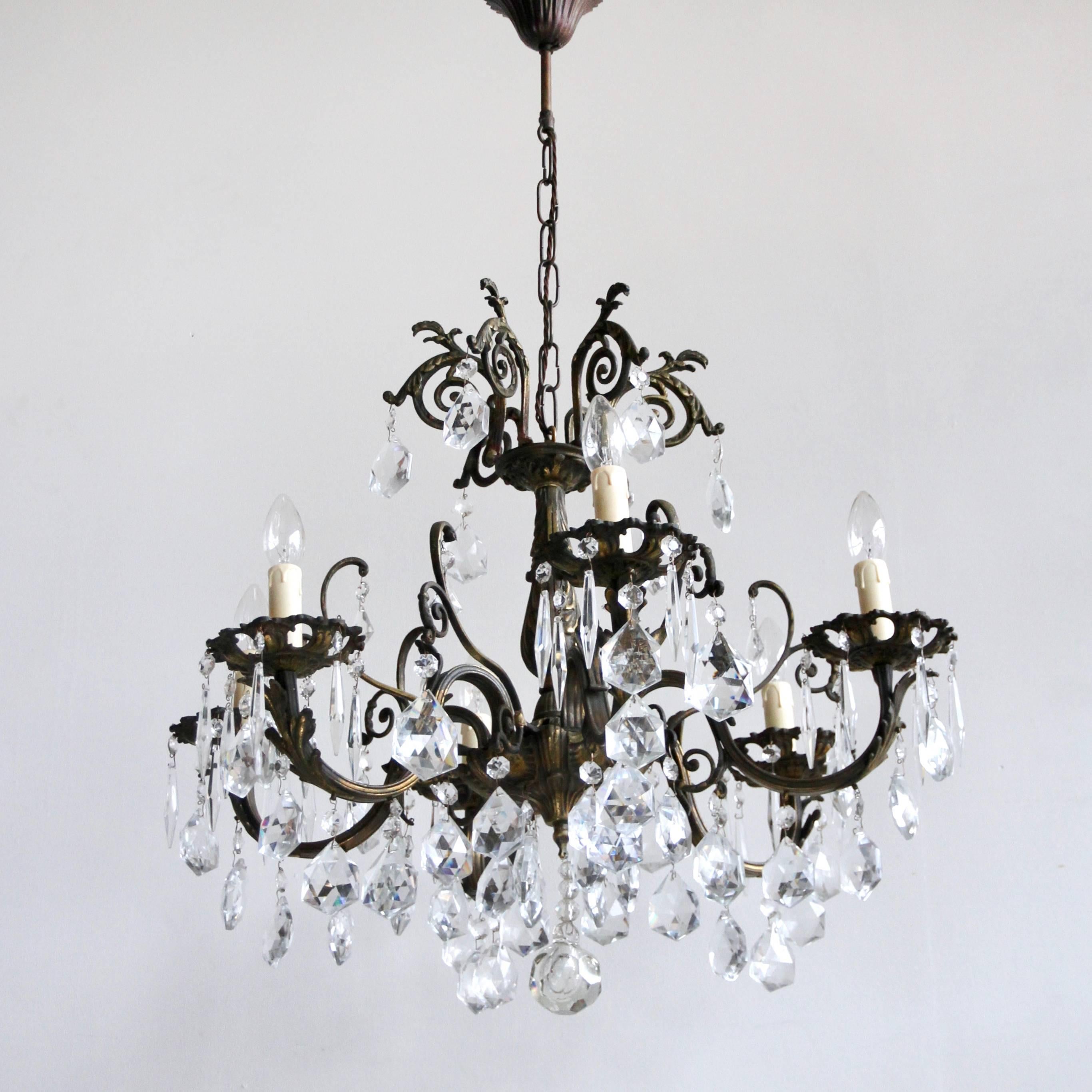 Fully rewired and restored this heavy cast ornate brass chandelier originates from 1920s France. Dressed in square cut crystal pears and crystal icicles it is an opulent centre piece. The chandelier would sit perfectly above a dining table in a